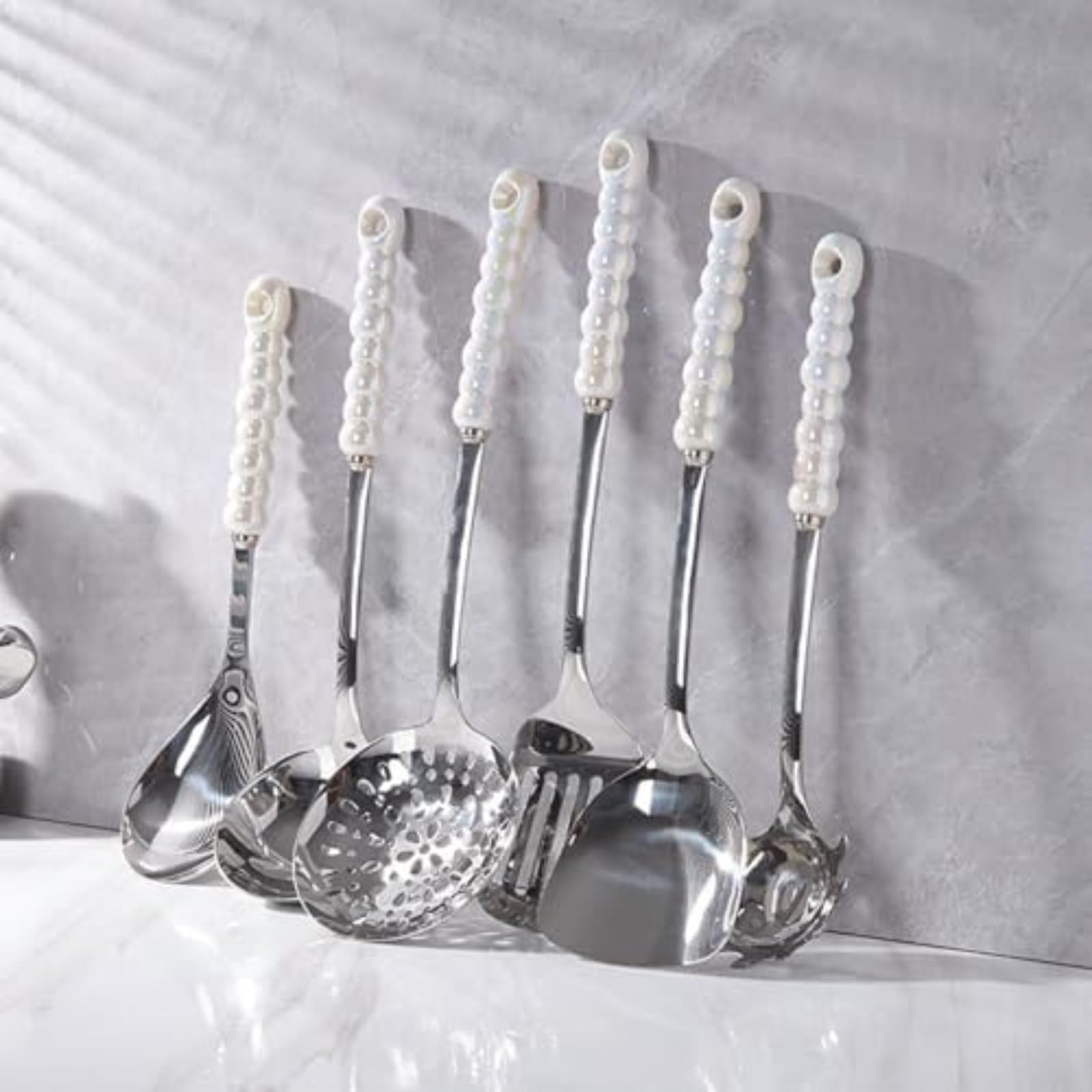 Set di 7 utensili da cucina di lusso in acciaio inossidabile con manici in ceramica decorati con perle, resistenti al calore, che comprende un mestolo, una spatola, un cucchiaio forato e una paletta.