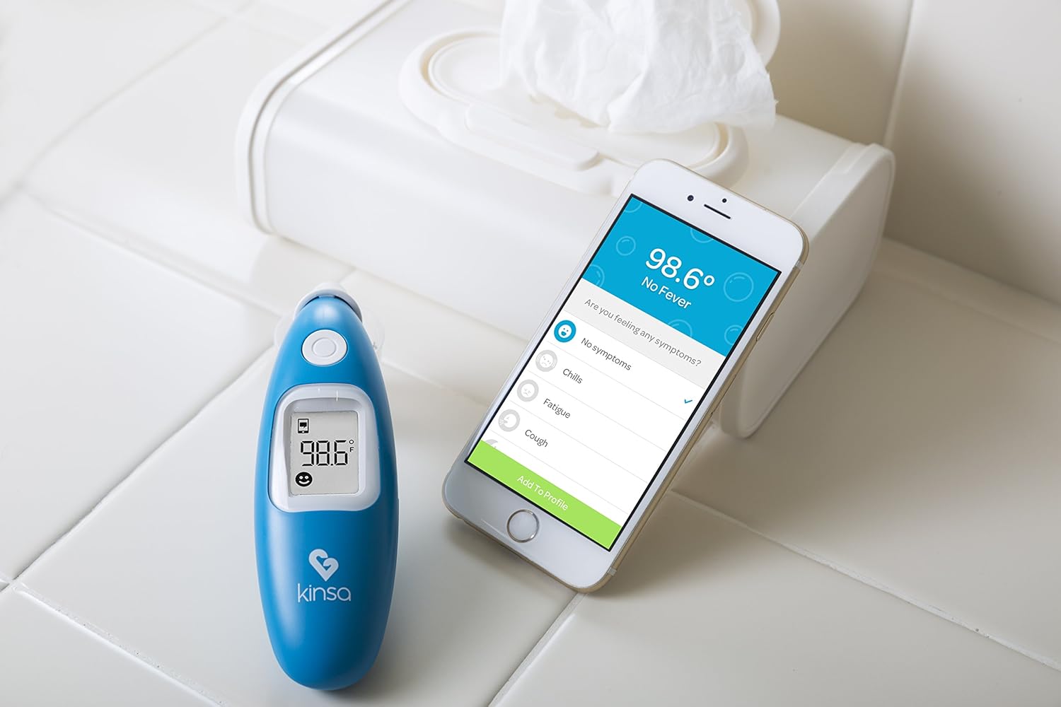 Kinsa Smart Ear Thermometer next to a smartphone displaying the Kinsa app