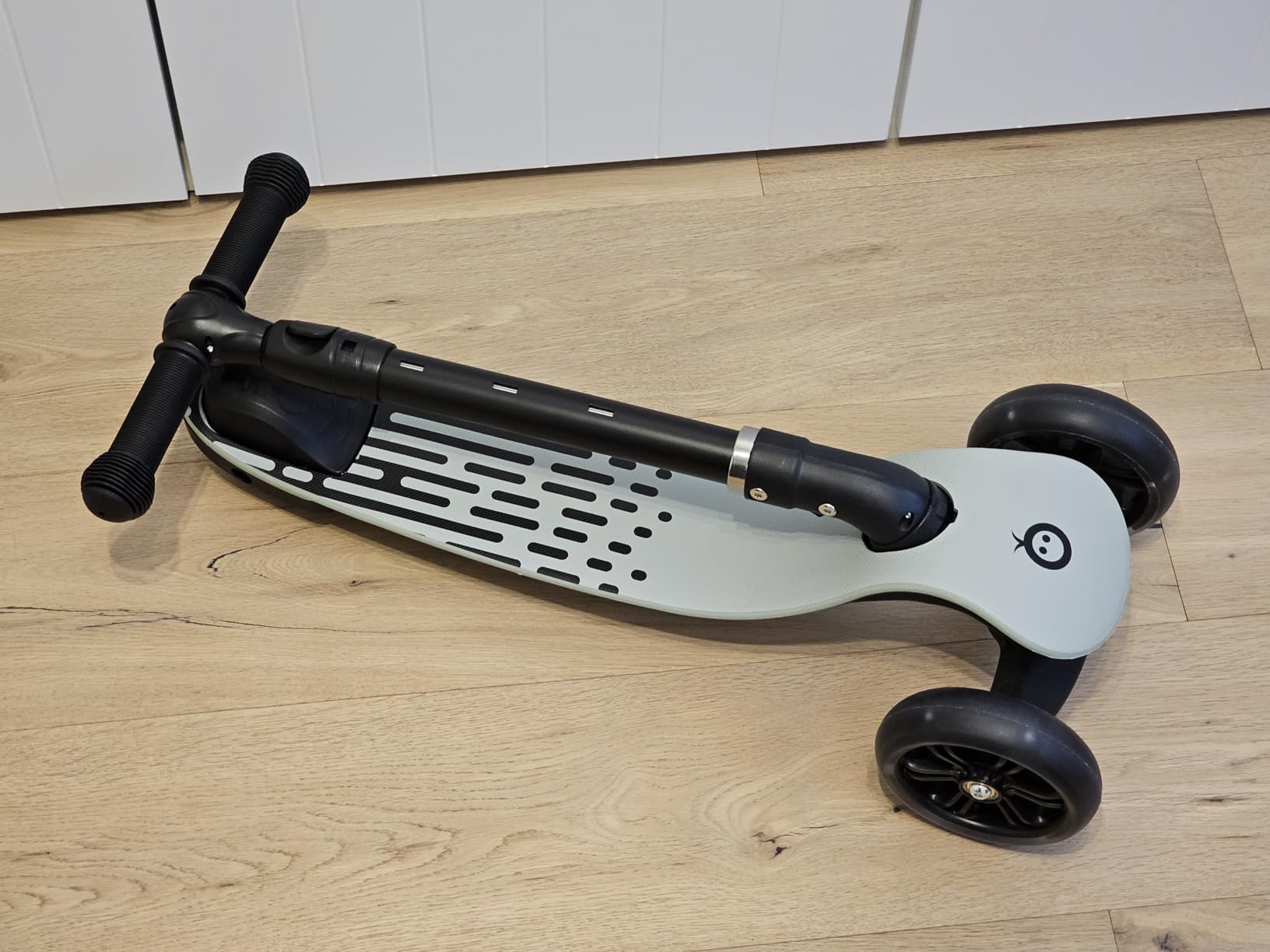 Image showing a child adjusting the handlebar height of the MoMi SAN scooter.