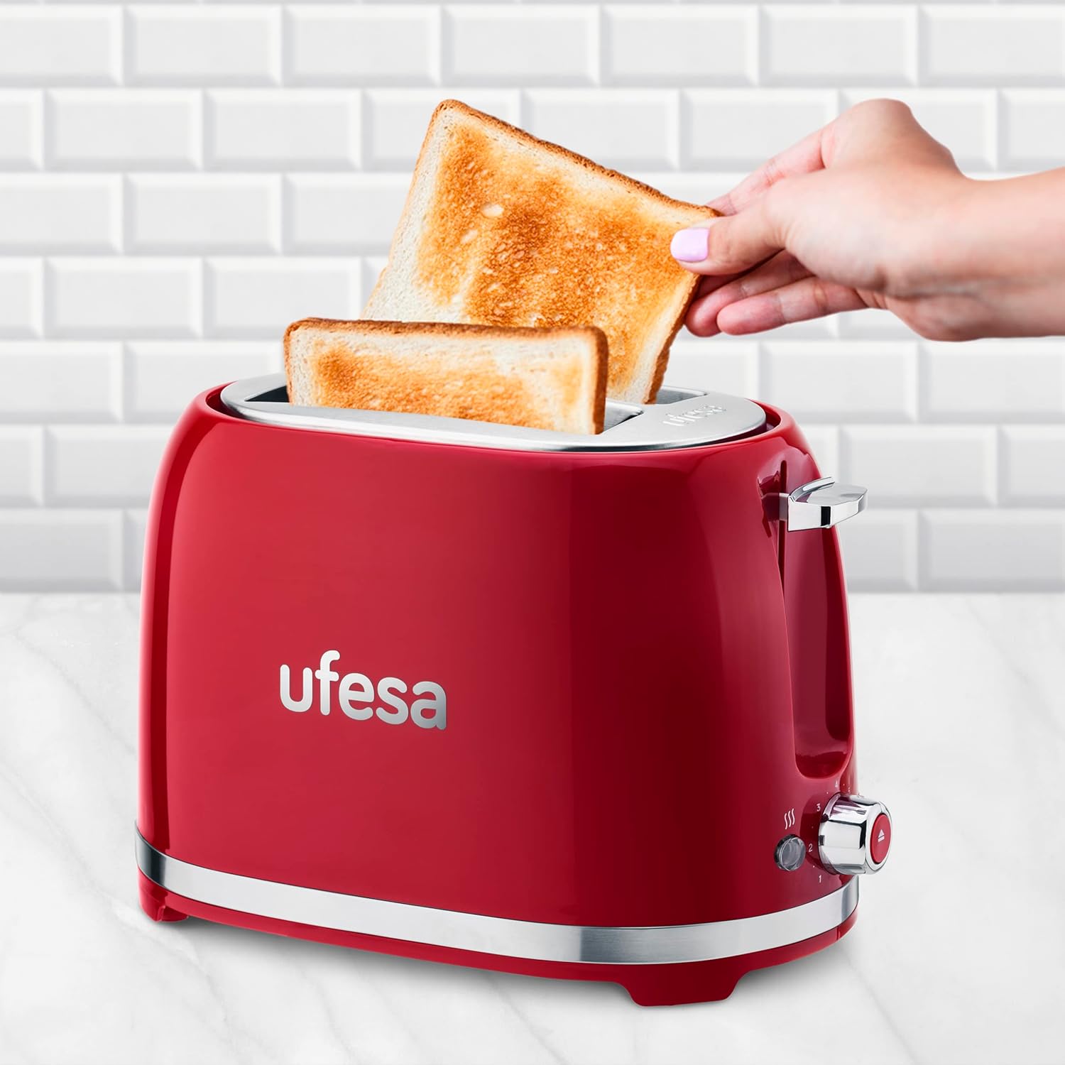 Aldea view of the Ufesa PinUp Classique Toaster with a hand inserting a slice of bread into one of the wide slots.