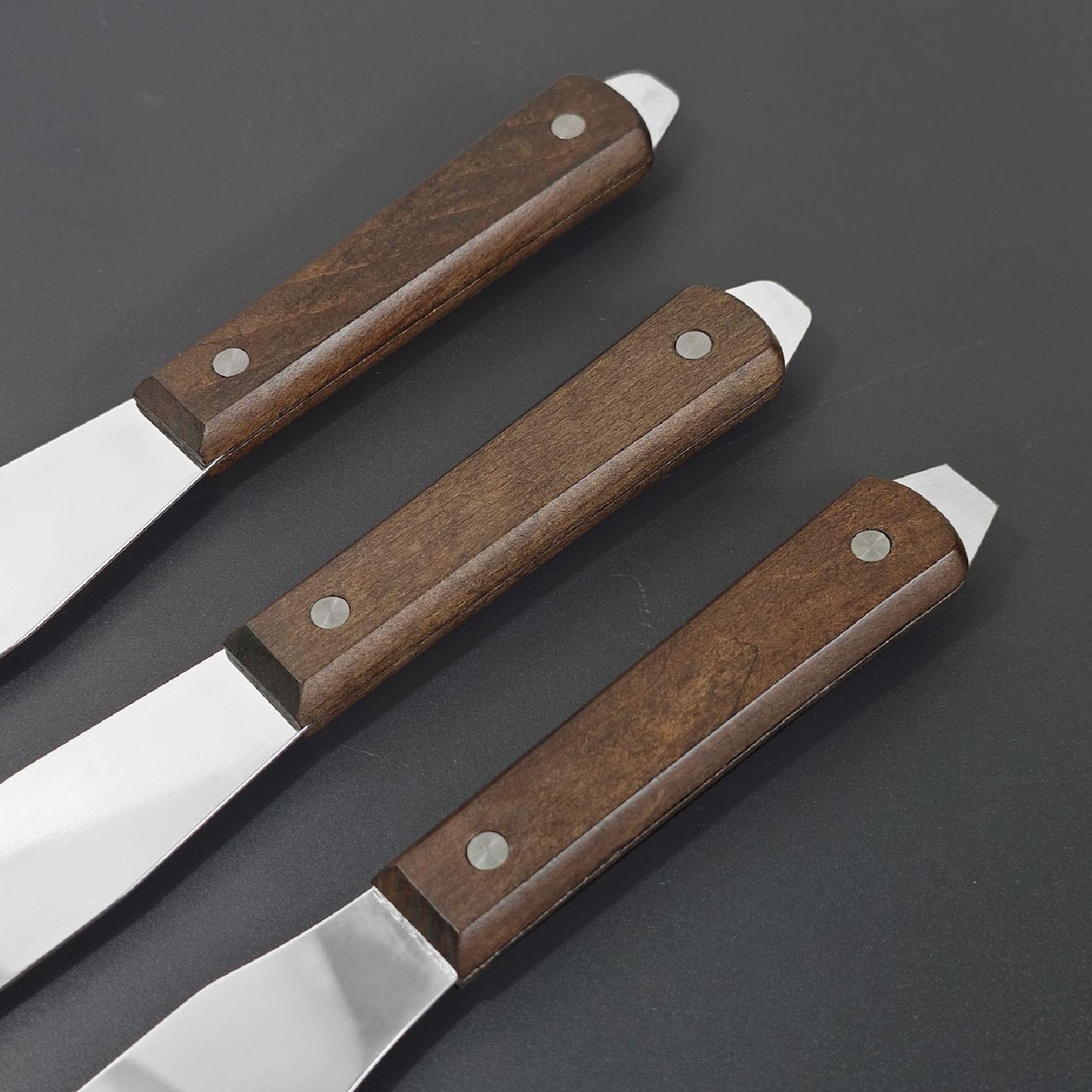 Juego de espátulas de acero inoxidable para repostería con mango de madera.