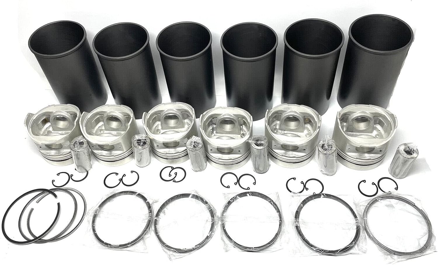 Various engine components from the rebuild kit including cylinder liners, pistons, and bearings