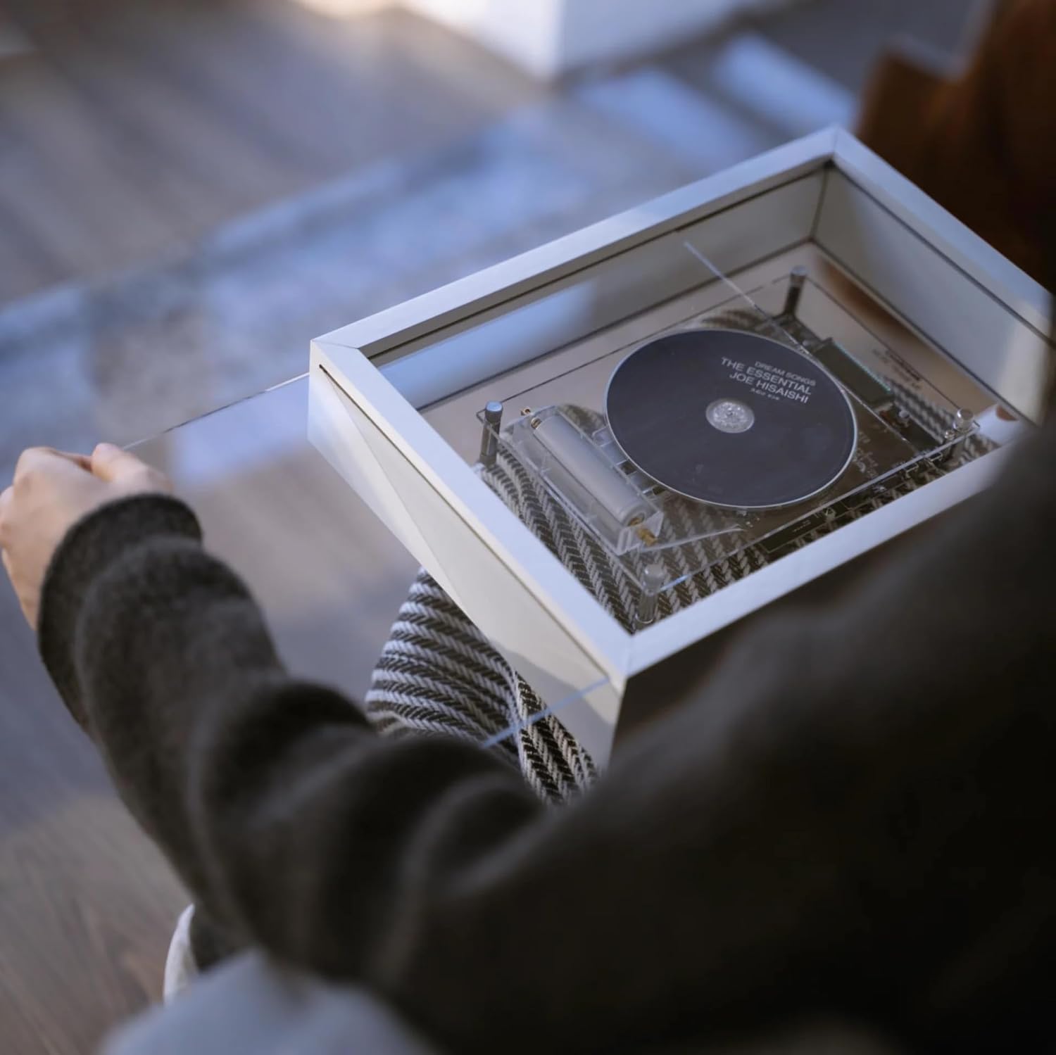 Hand loading a CD into the COOLGEEK M1 Transparent CD Player