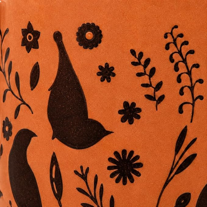 Detalhe da estampa da caneca L'Hermitage Murale em terracota, destacando os pássaros e flores pretos em close