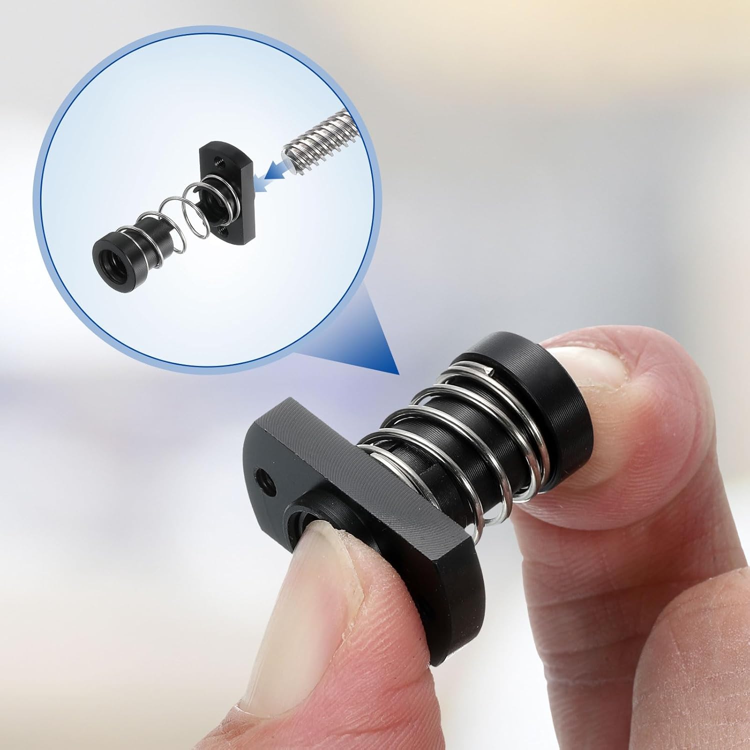 A hand demonstrating the compression of the anti-backlash spring nut, showing the internal spring mechanism.