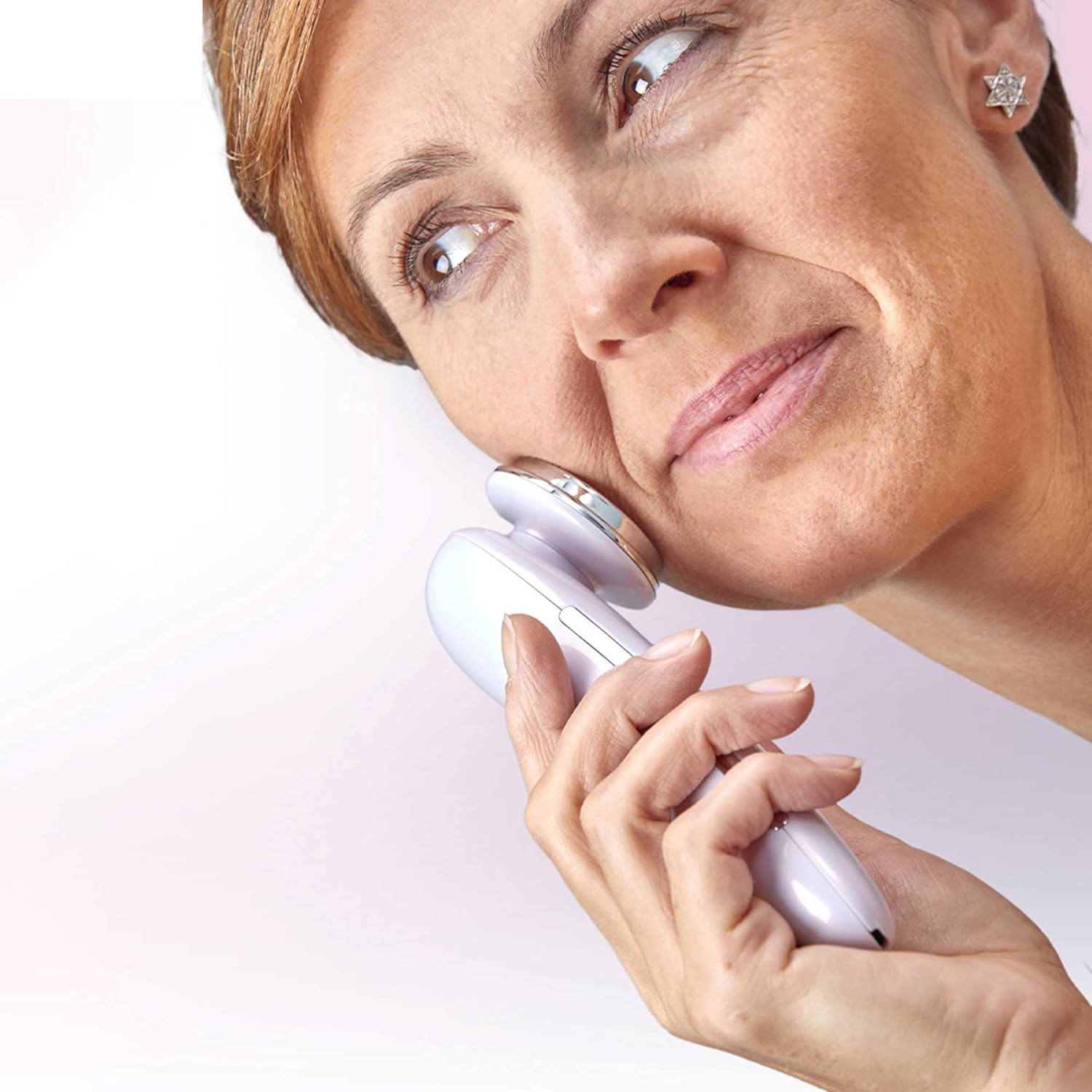 A woman using the Lanaform Pureskin LA131312 facial care device on her cheek, looking upwards.