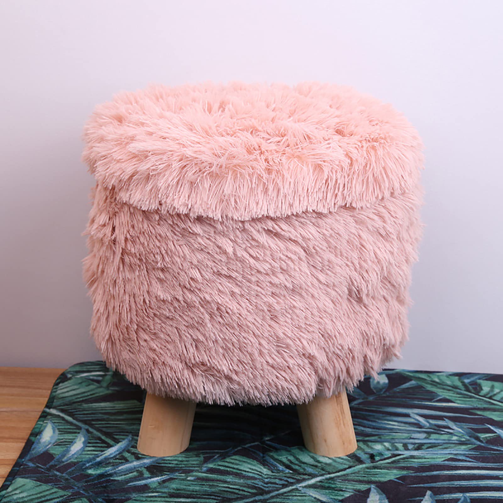 Tissu touffeté et pieds en bois pour ce repose-pieds de rangement rose