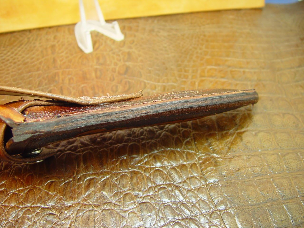 Vertical left-hand sheath for the buck 105 knife. The sheath is made out of 8 ounce leather hand tooled with a feather. The sheath is for the buck 105 knife are the sprayed Golden Spike will fit this sheath also. This is a left hand carry sheath. Sheath only knife not included.