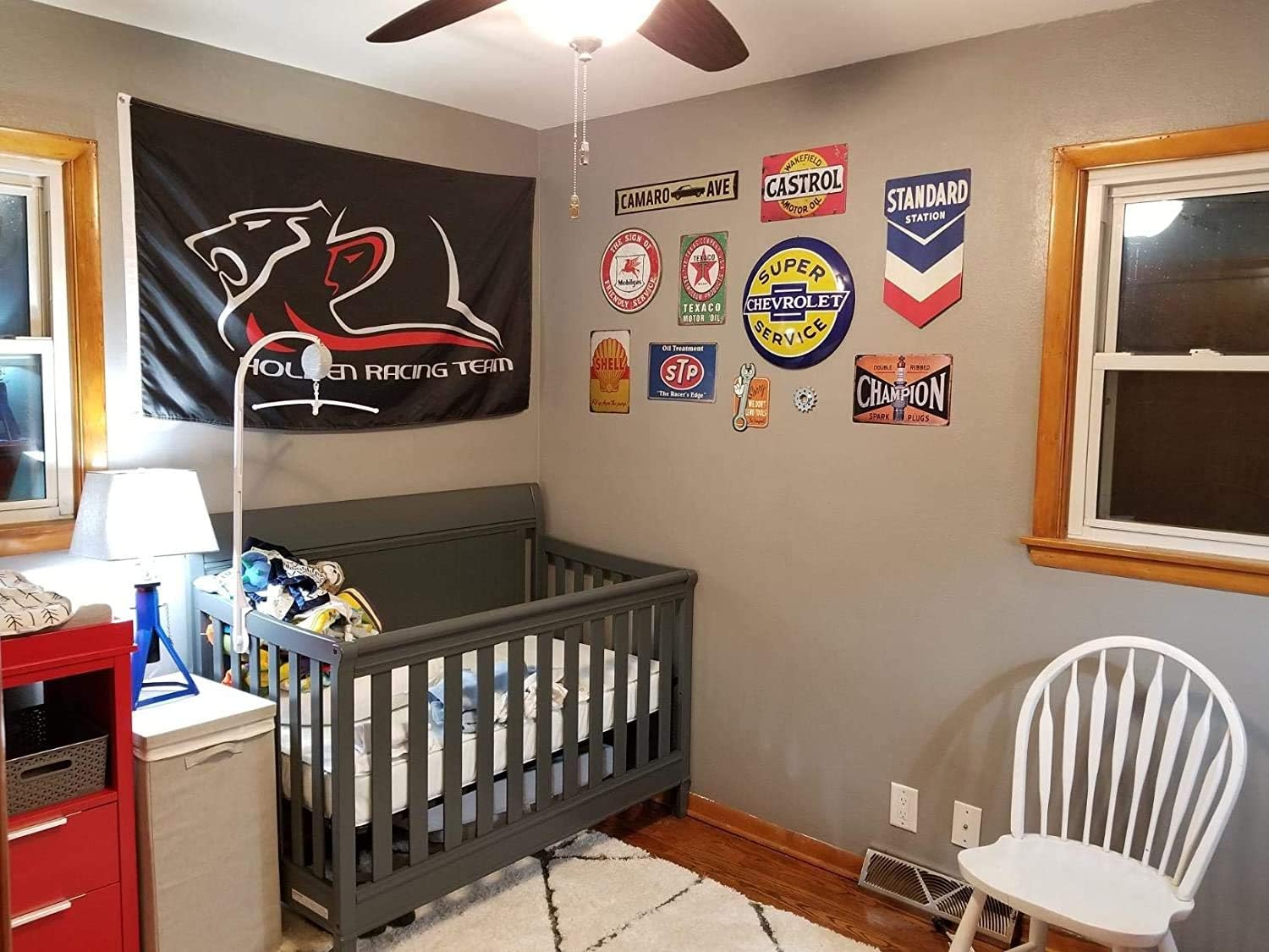 The Duck Hunt tin sign displayed on a grey wall in a child's room or nursery, above a crib, alongside other decorative signs and a large black flag.