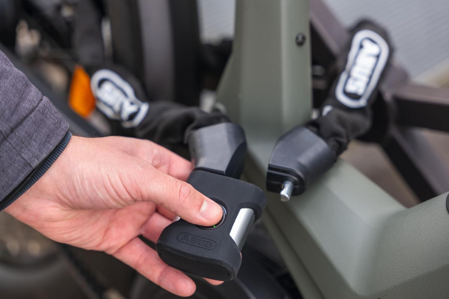 Hand holding ABUS lock mechanism with fingerprint sensor