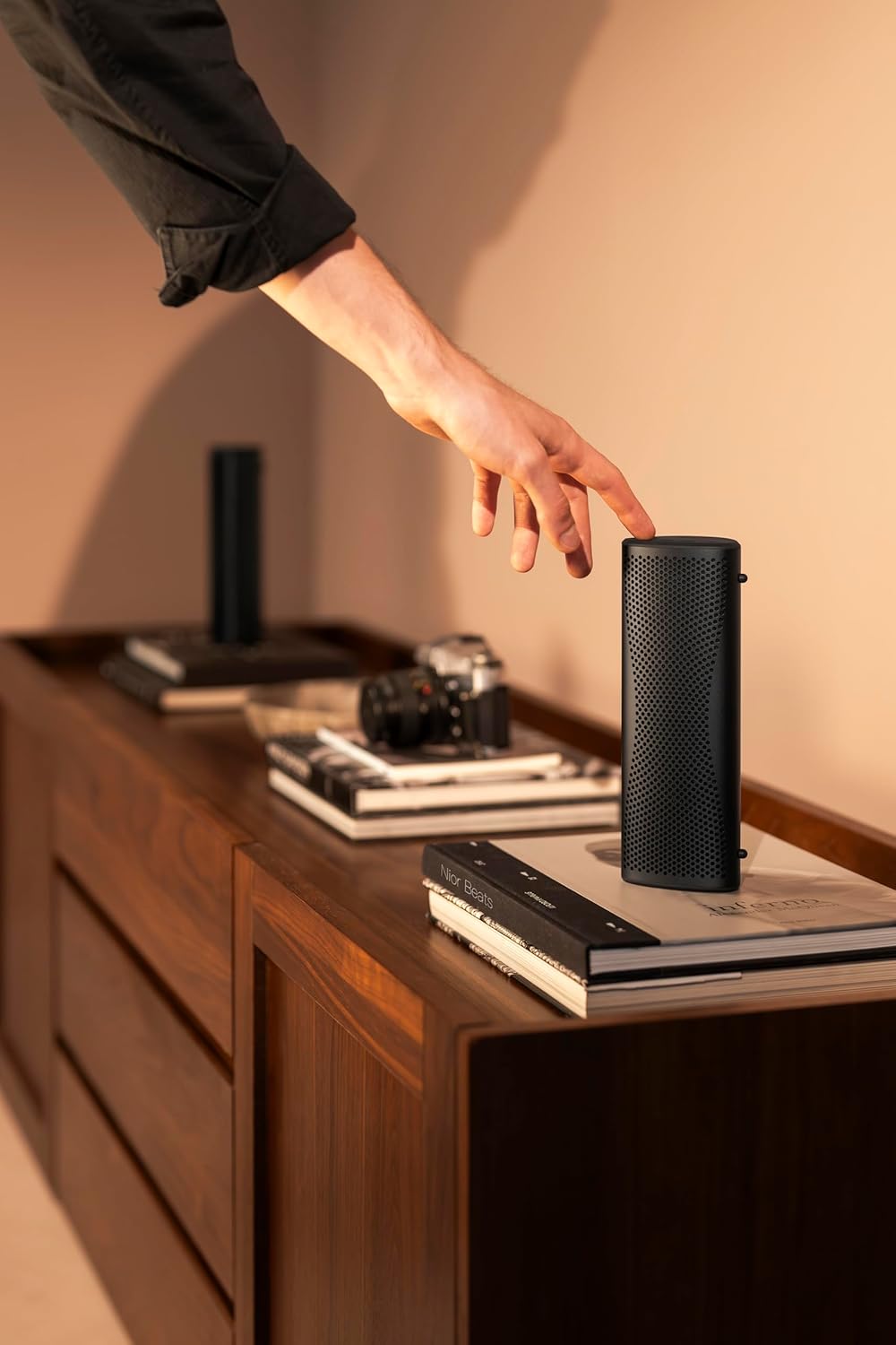 KEF Muo Portable Speaker, standing upright on a wet surface, demonstrating its waterproof feature