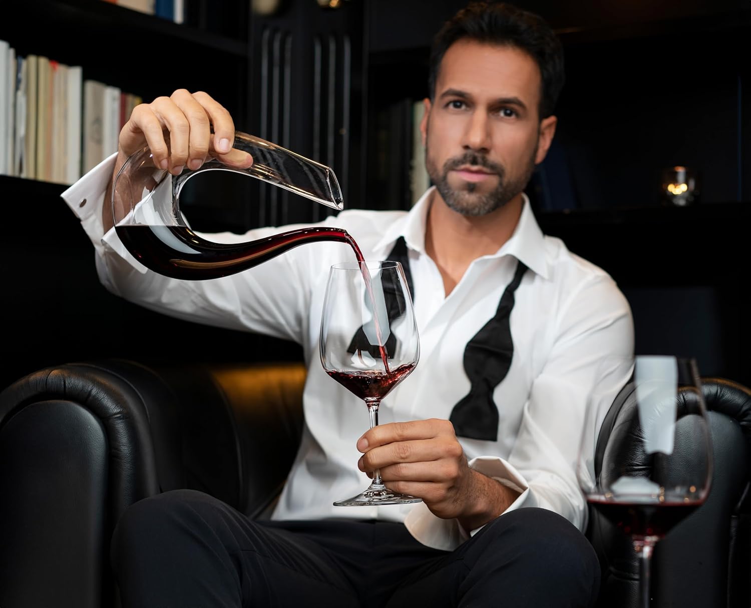 Man pouring red wine into a Riedel Vinum Extreme glass