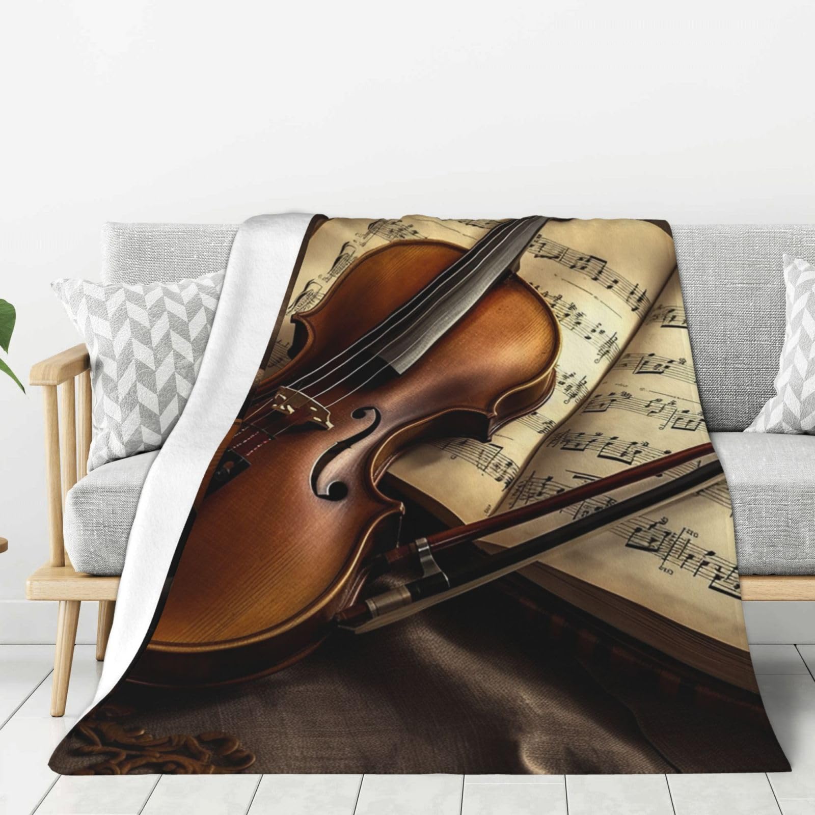 Plaid polaire violon et livre pour vos soirées lecture sur le canapé