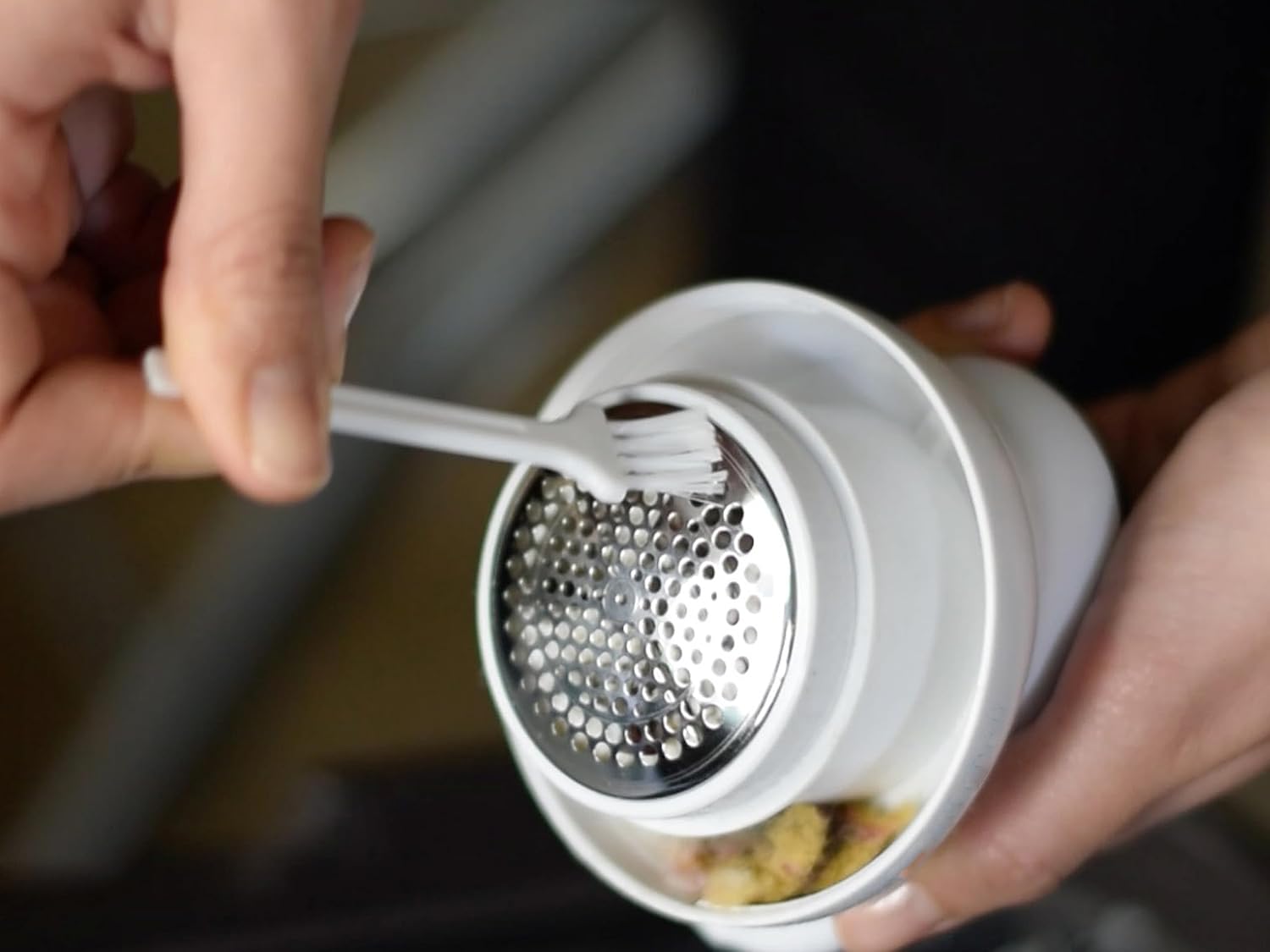 Using the cleaning brush to clean the blades and grid of the BEPER 50.245 Lint Remover