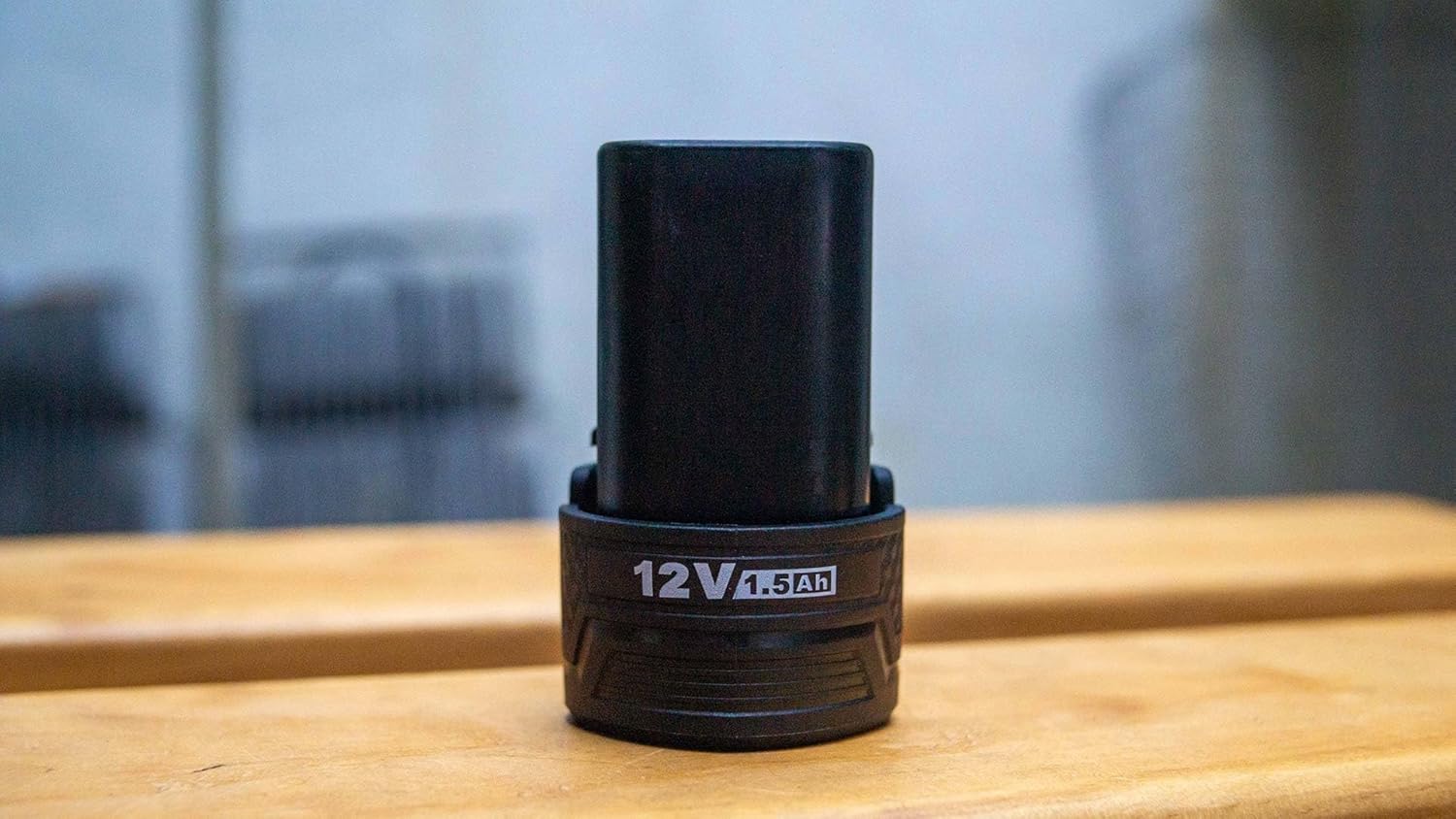 TOTAL 12V 1.5Ah Lithium Battery standing on a wooden surface