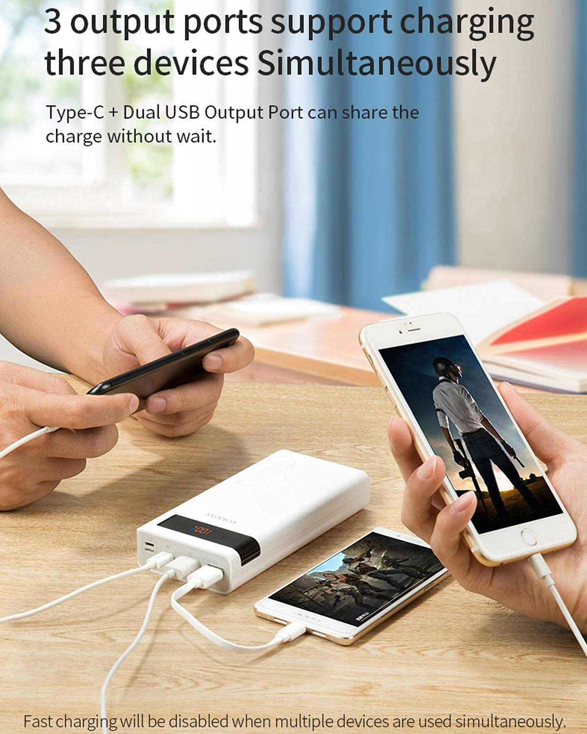 Hands connecting charging cables from Romoss Sense 8P+ Power Bank to two smartphones, demonstrating simultaneous charging.