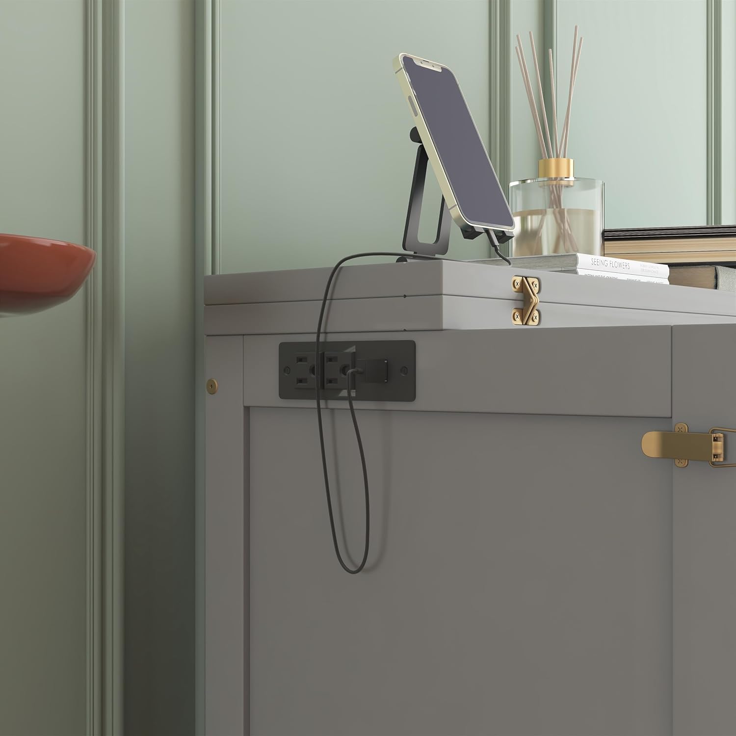 Close-up view of the integrated charging station on the LUMISOL Murphy Bed, showing two power outlets and two USB ports with a phone charging.