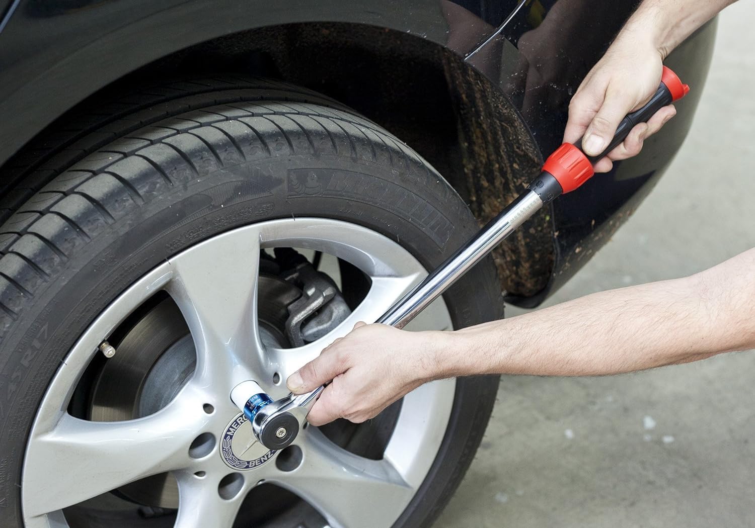 Person using the Vigor V3441 torque wrench to tighten a car wheel nut