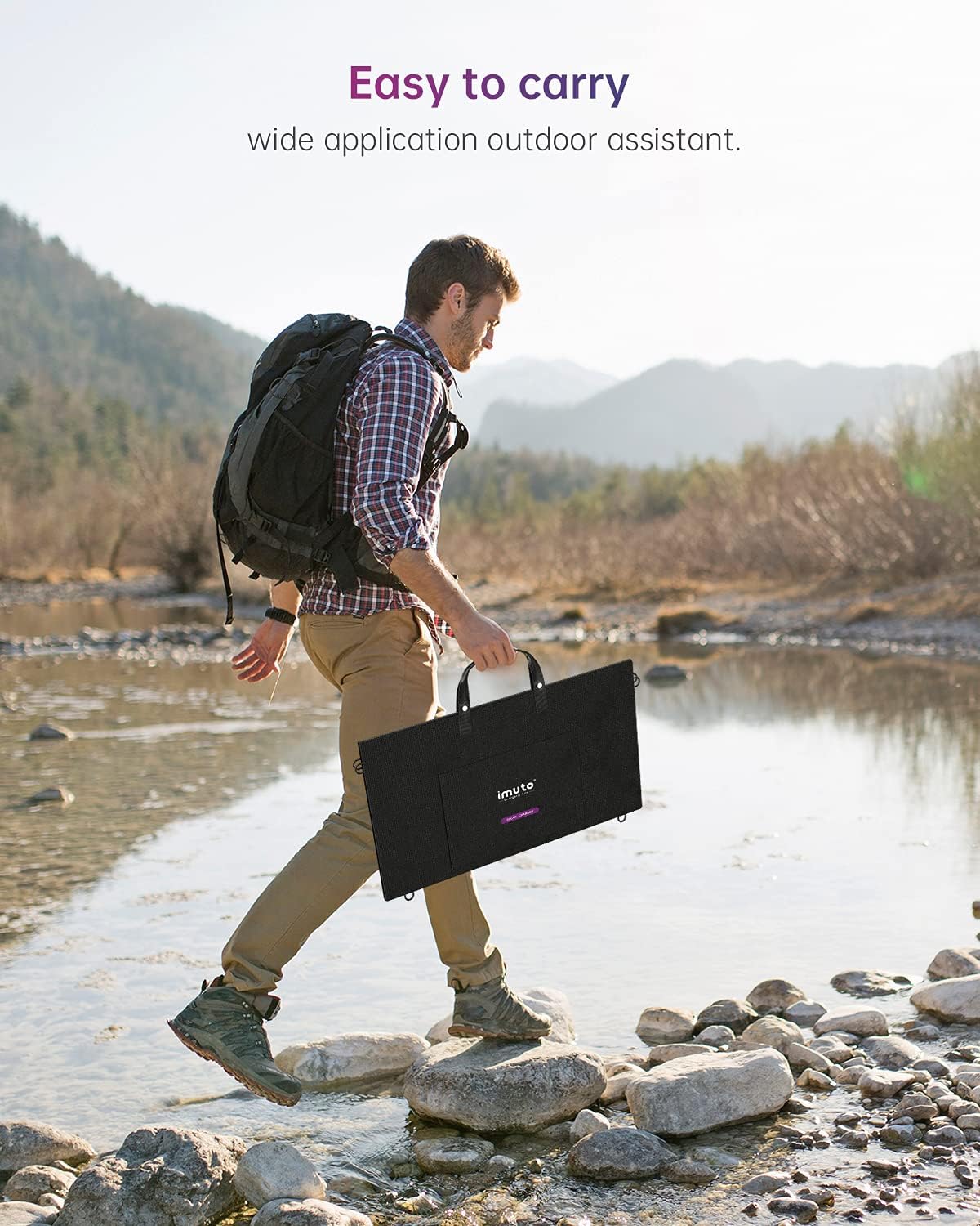 A person carrying the folded imuto 100W Portable Solar Panel by its handle while walking outdoors.