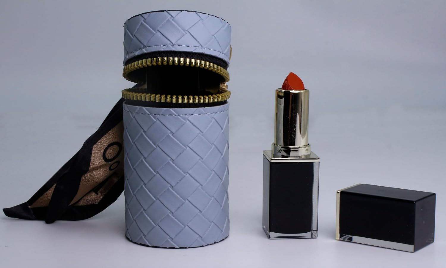 Zipper lined lipstick holder cover with gold hardware pendant, ribbon accessory, light blue