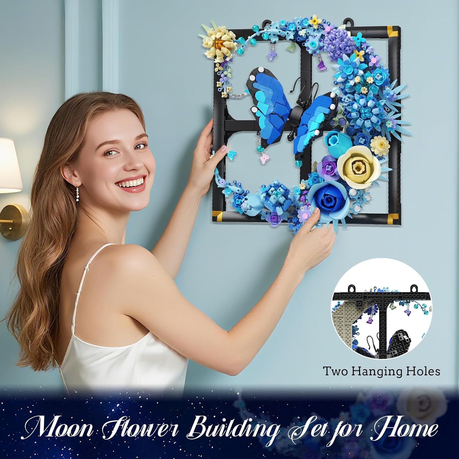 A woman hanging the Moon Flower Building Set on a wall, highlighting the two integrated hanging holes.