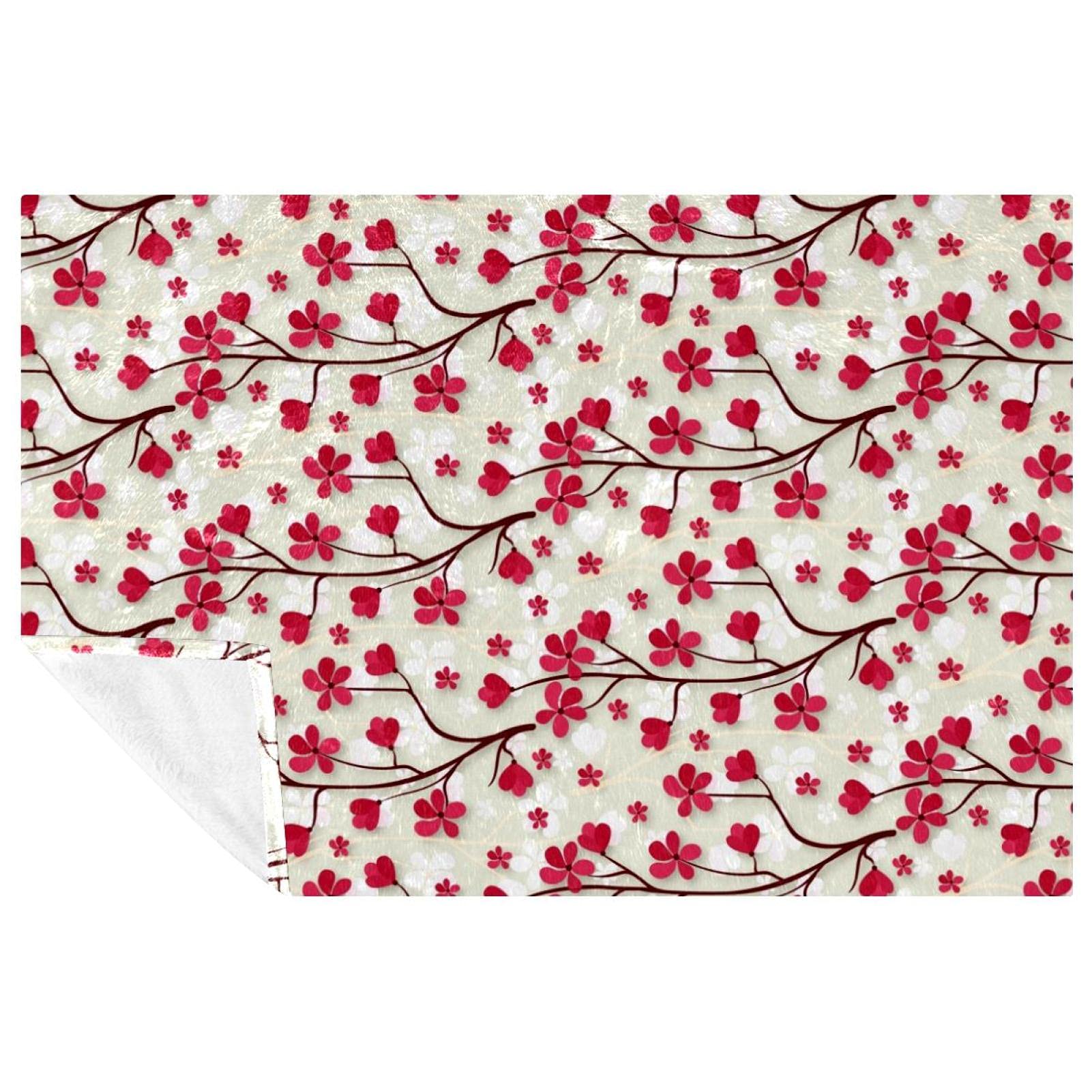 Plaid fleurs de cerisier rose pour des instants cocooning chaleureux sur le lit