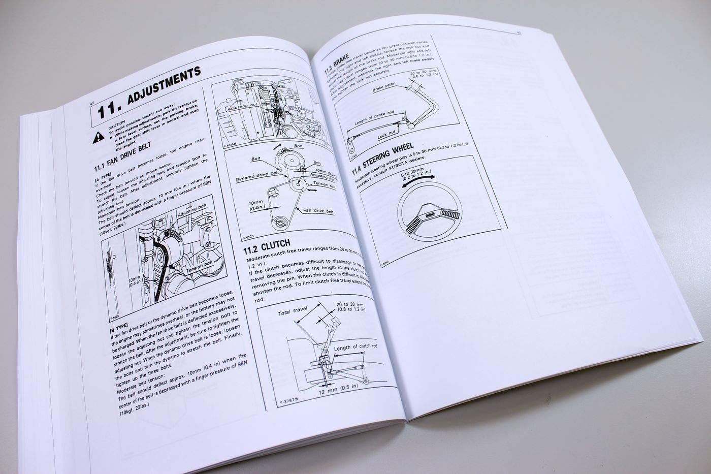 Pages from the Kubota tractor manual showing section '11. Adjustments', with diagrams for fan drive belt, clutch, brake, and steering wheel adjustments.