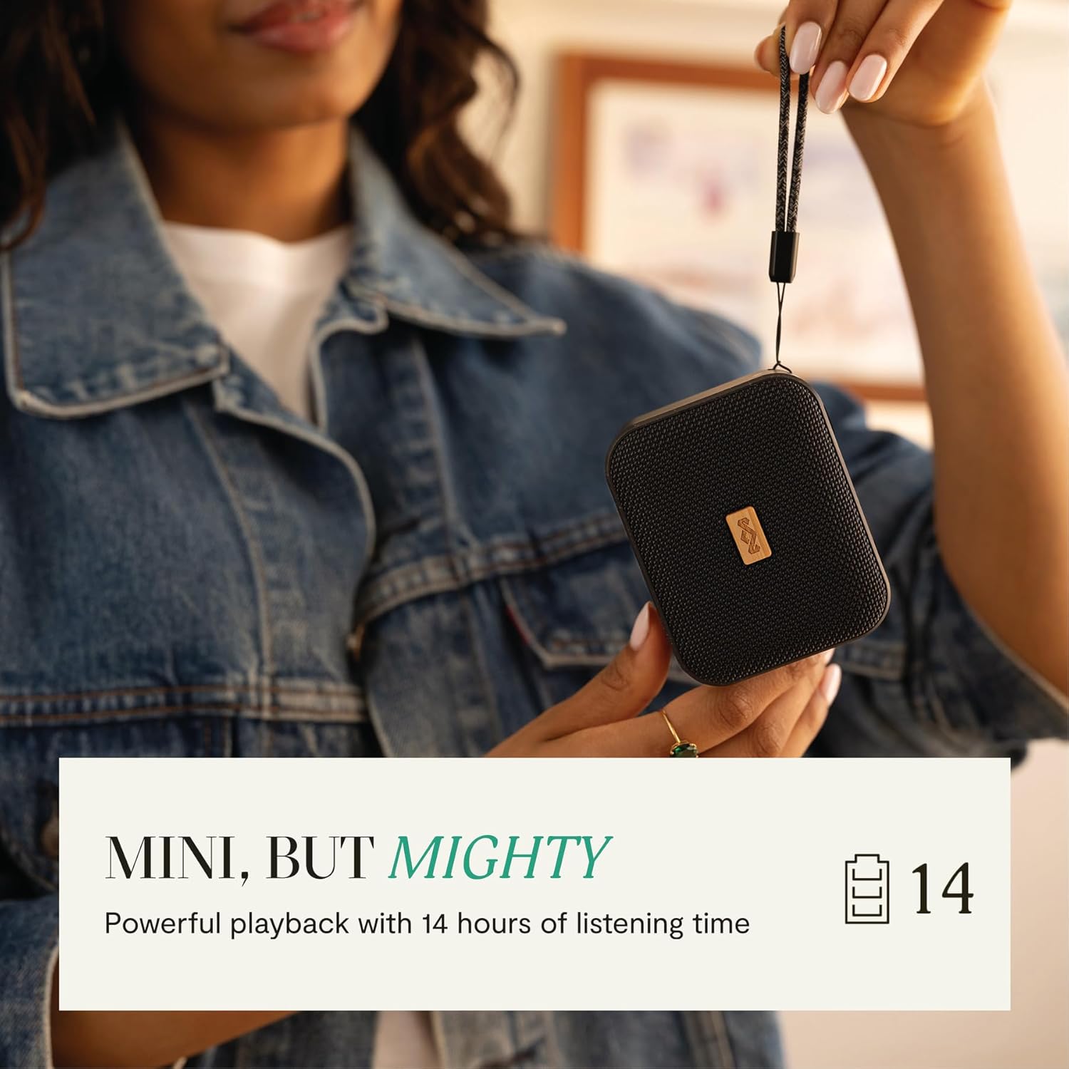 A hand holding the compact House of Marley Jammin' speaker, illustrating its small size.