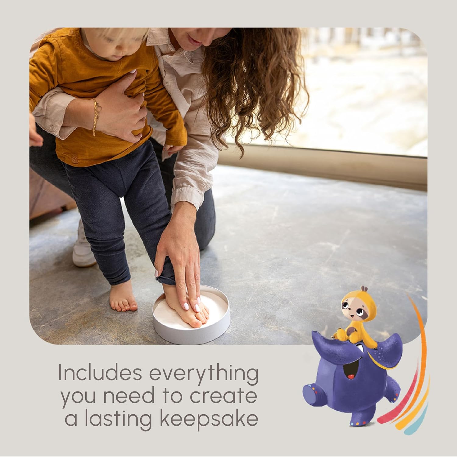 A parent holding a baby and guiding their foot into the clay inside the round magic box, with a toy elephant in the foreground.