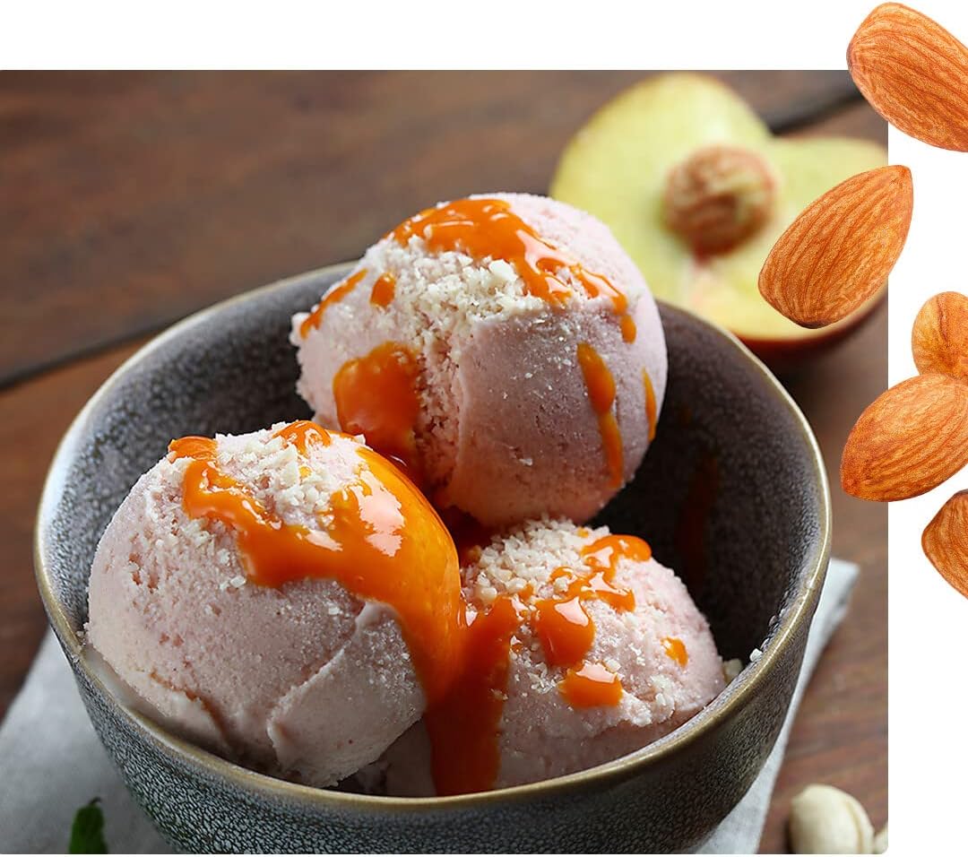 A bowl of finished peach ice cream with a sauce and almond topping.