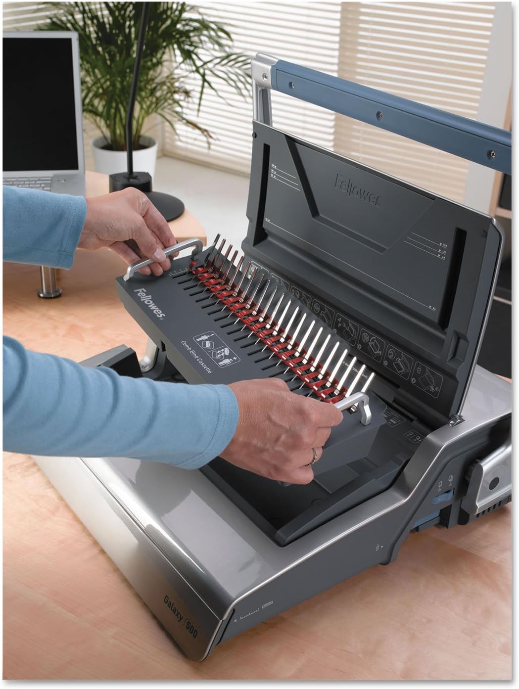 User inserting a binding comb into the Fellowes Galaxy binding machine