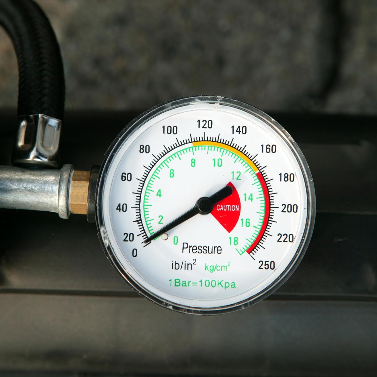 Close-up view of the analog pressure gauge on the Unitec Cartrend 10924 compressor, showing pressure readings in bar and PSI.