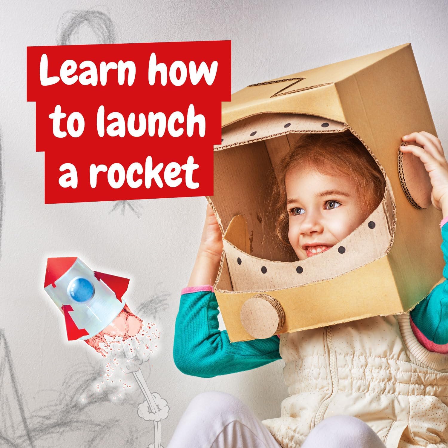 A young girl wearing a cardboard astronaut helmet, watching a toy rocket launch.