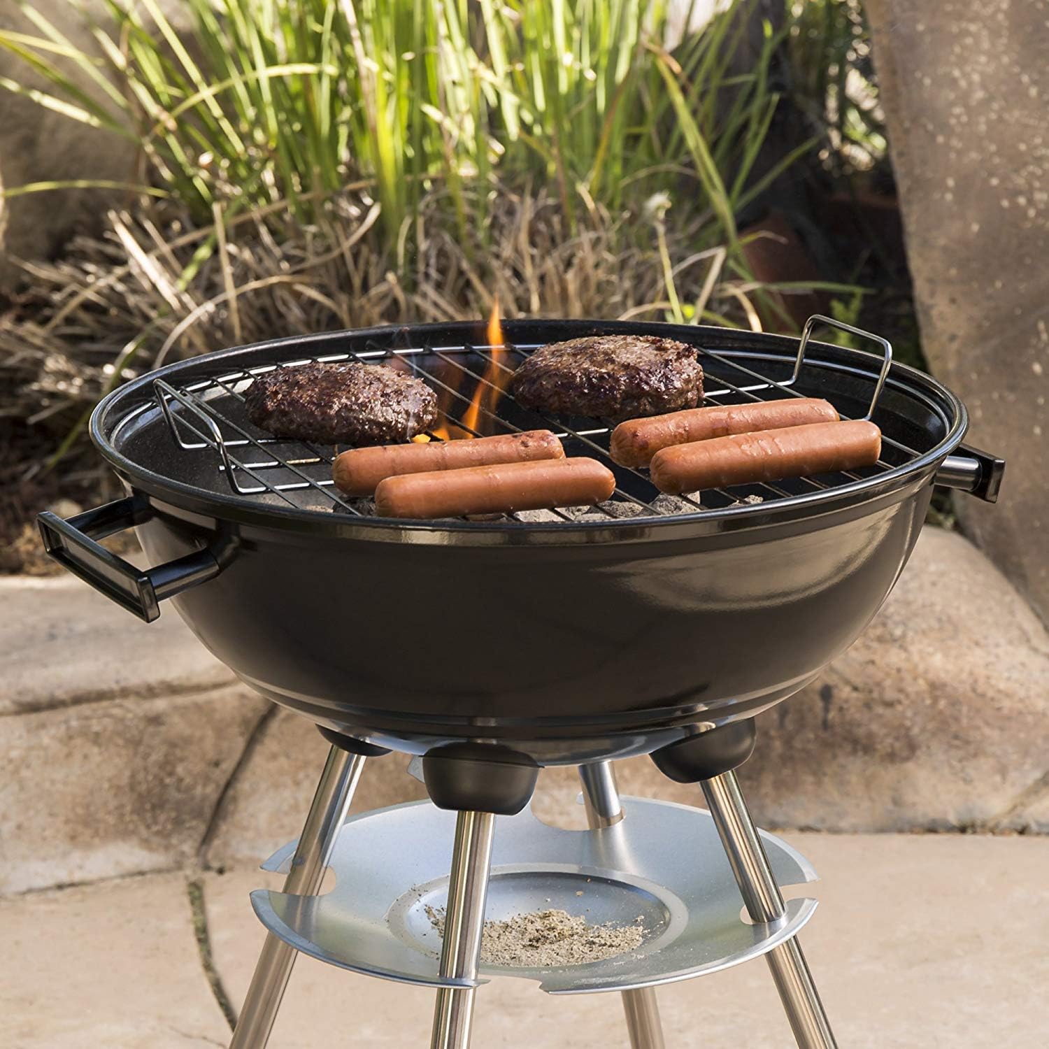 A ZOKOP charcoal grill in use, with burgers and hot dogs cooking on the grate, showing flames and smoke.