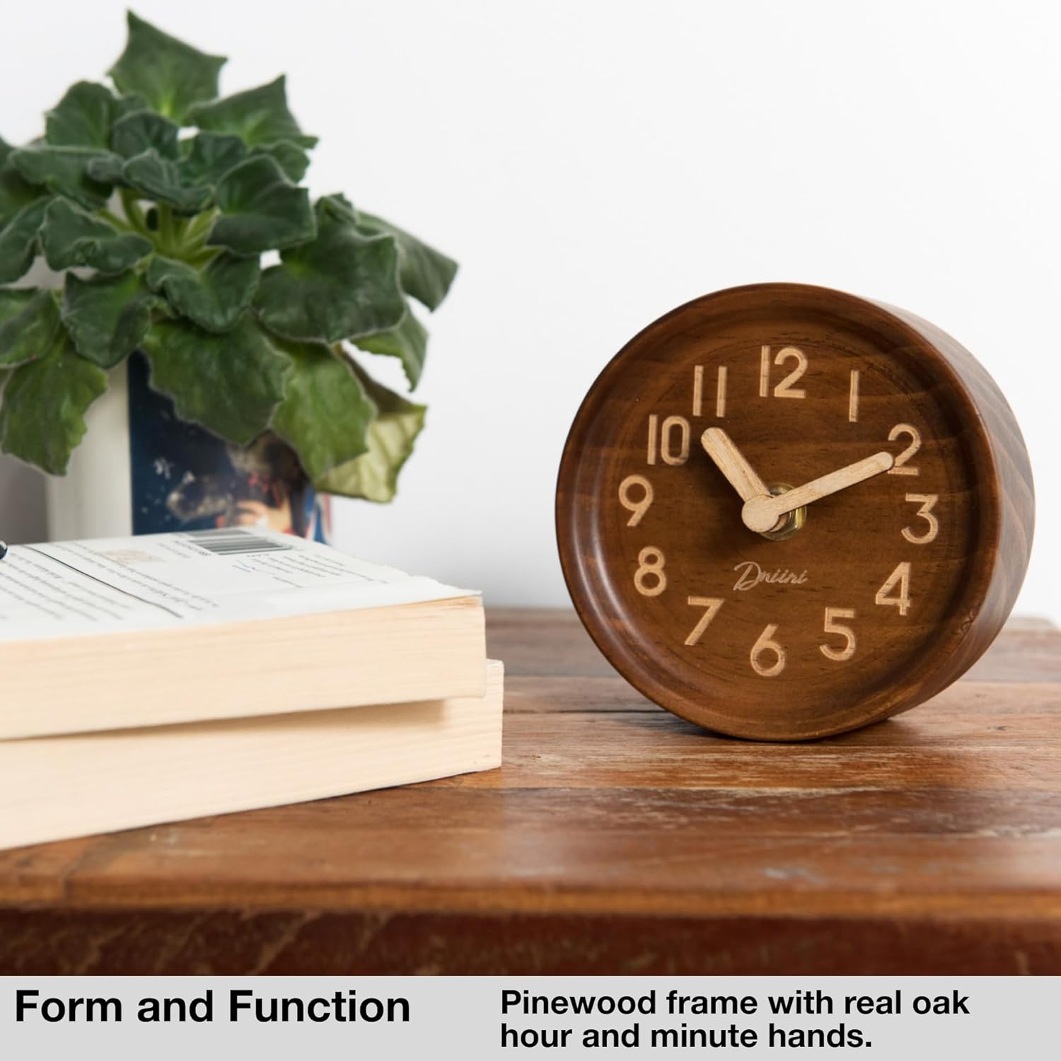 Driini Wooden Analog Desktop Clock on a wooden table next to books and a plant, showcasing its aesthetic appeal.