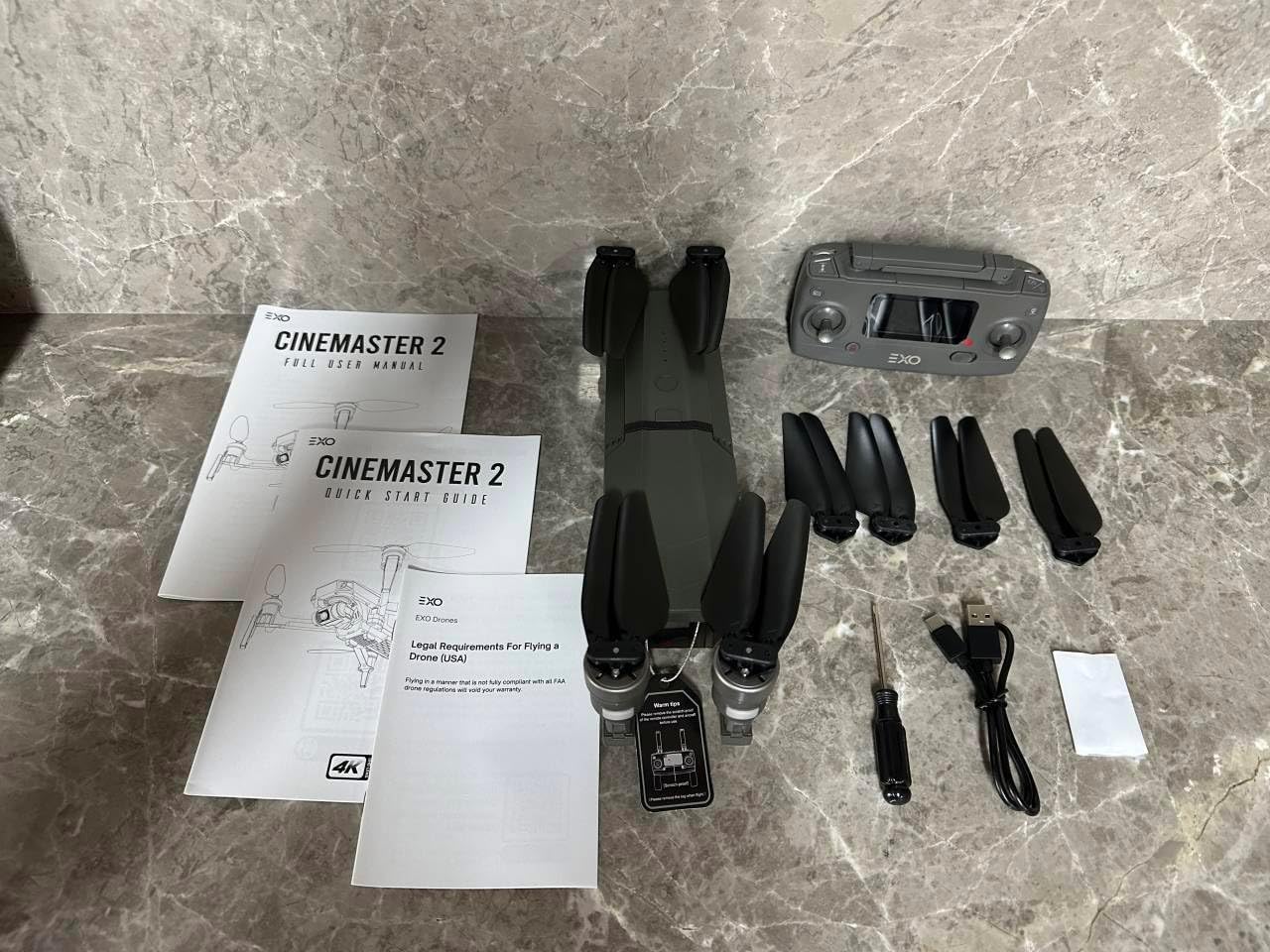 All components of the EXO CINEMASTER 2 drone package laid out on a surface