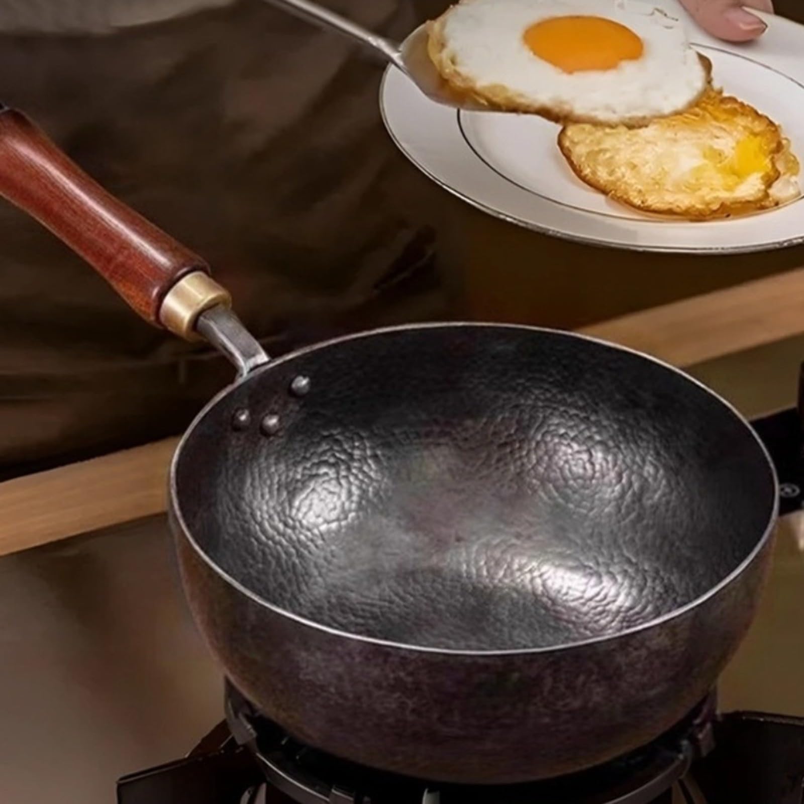 Hand-Hammered Cast Iron Wok 24 cm Wooden Handle | El compuesto de metal sólido se coloca en la zona de cocción, distribuye el calor de manera uniforme y facilita la cocción.