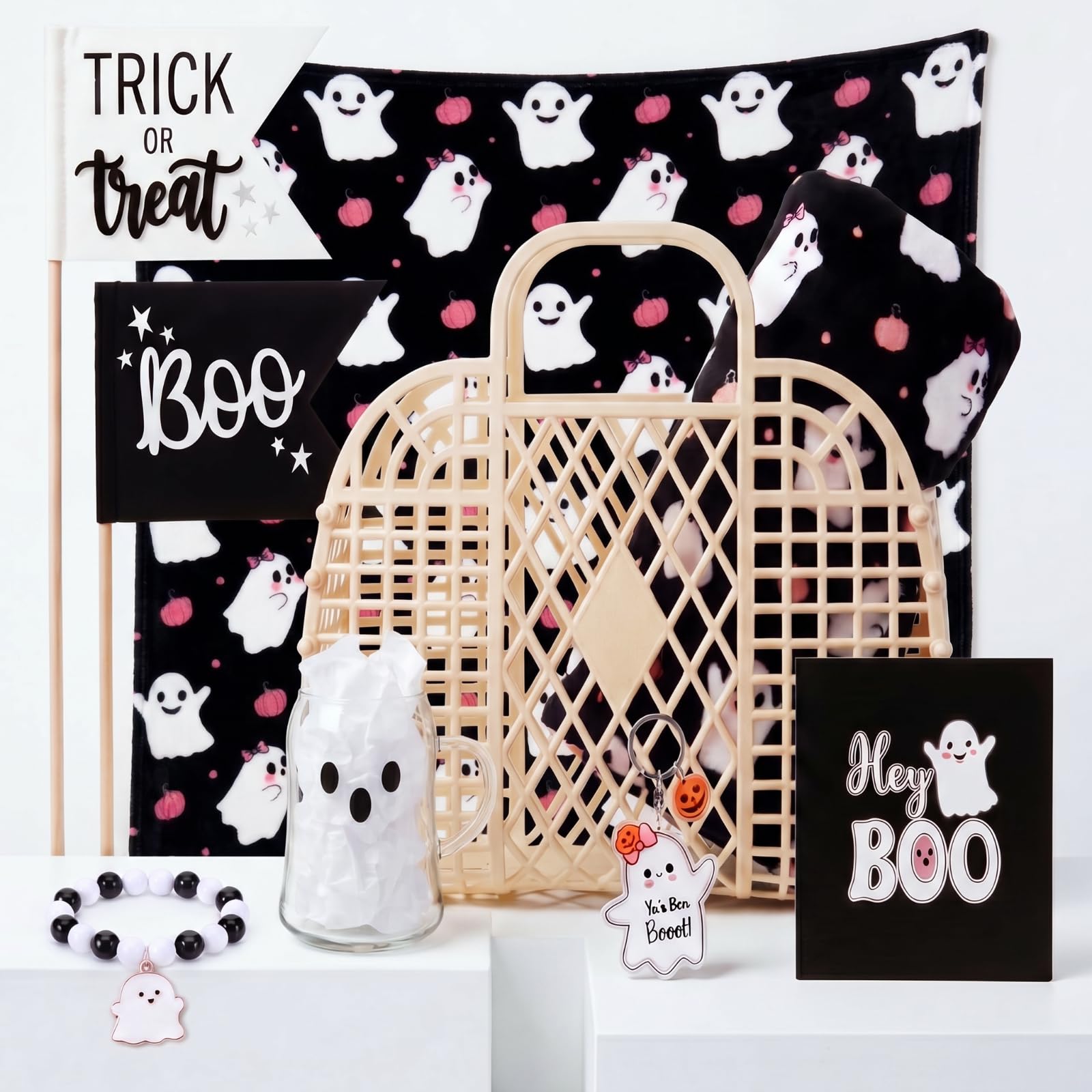Manta fantasma y vasos en cesta de Halloween para tardes acogedoras en casa