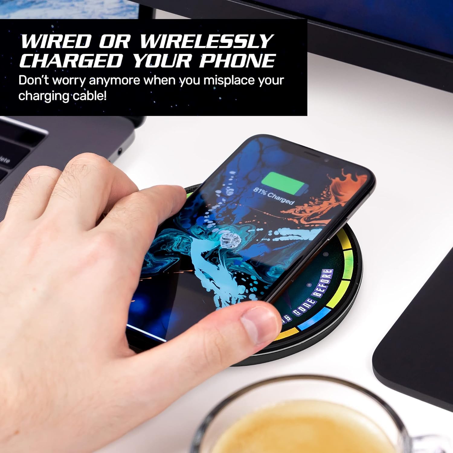 A hand placing a smartphone on the FAMETEK Star Trek Illuminating Wireless Charger for wireless charging.