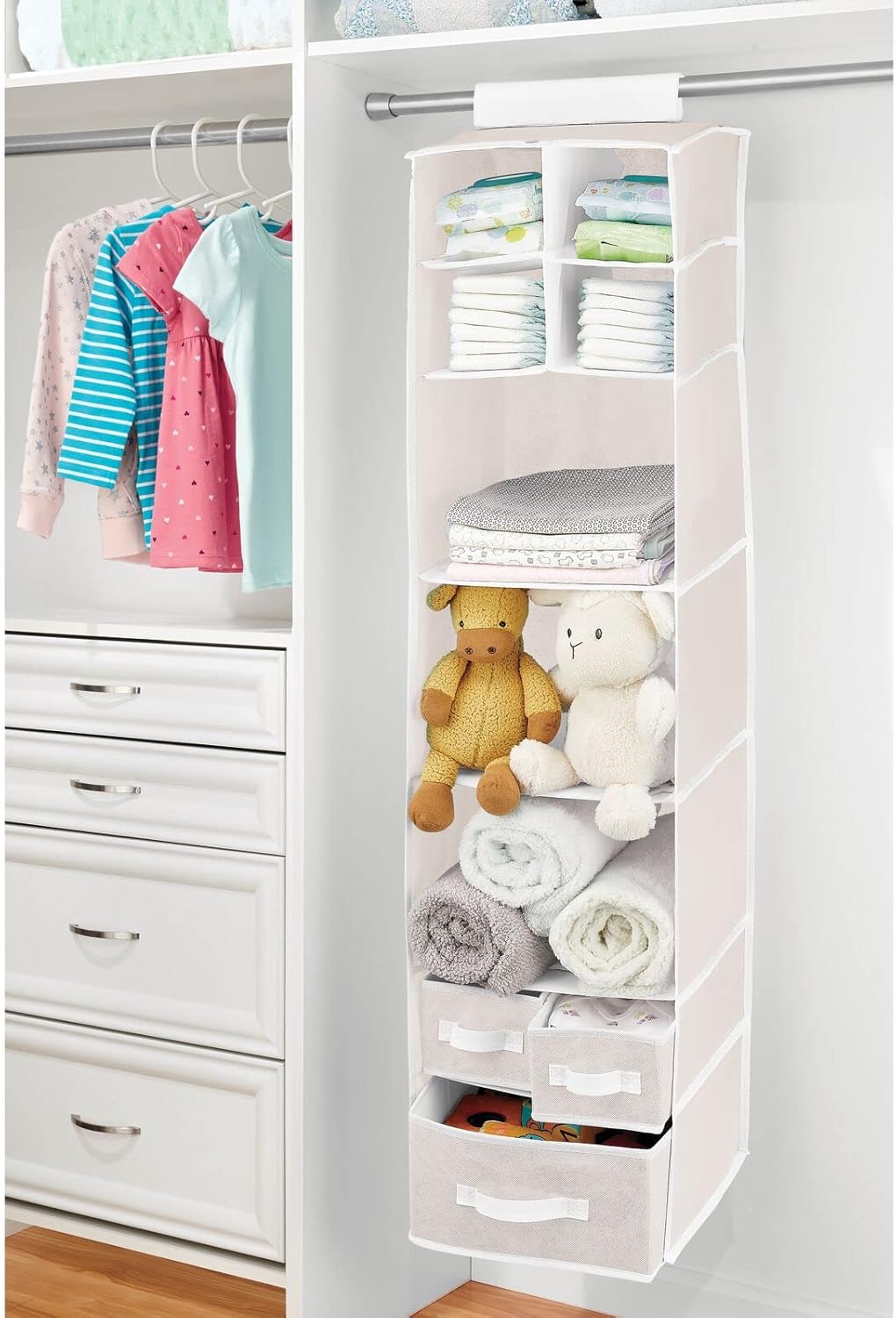 mDesign hanging organizer filled with baby clothes, diapers, stuffed animals, and rolled towels.