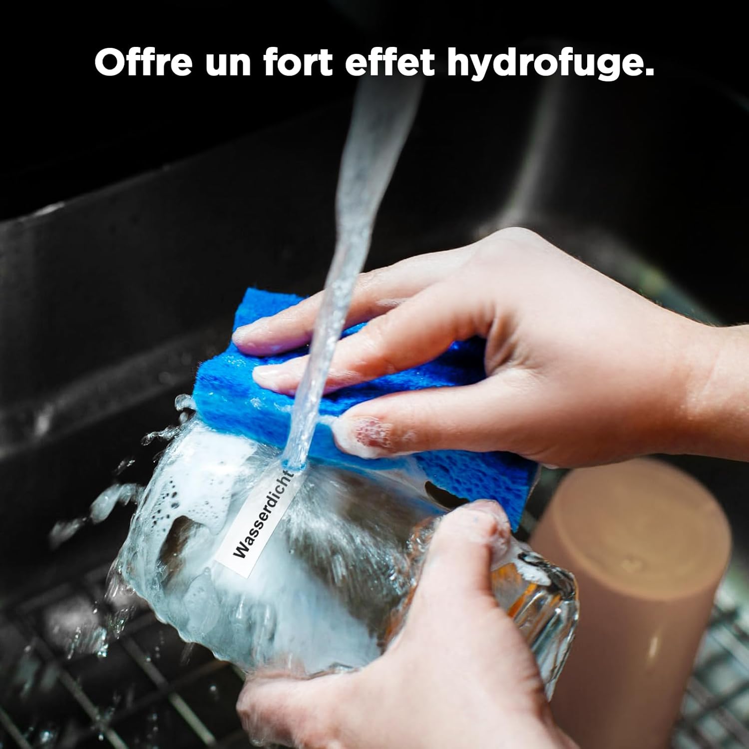 Hand washing a mug with a label, demonstrating waterproof feature