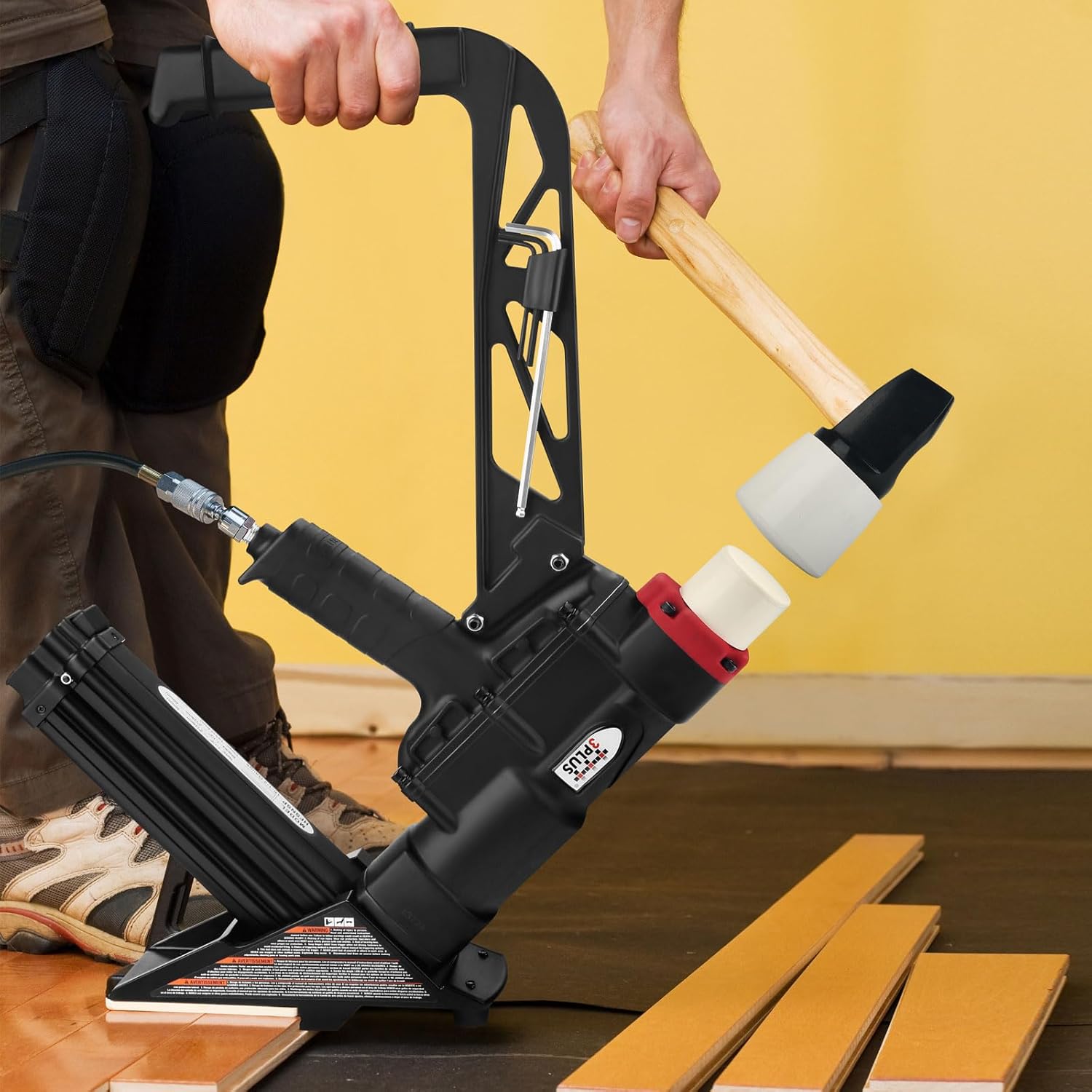 Person striking the nailer with a mallet during flooring installation