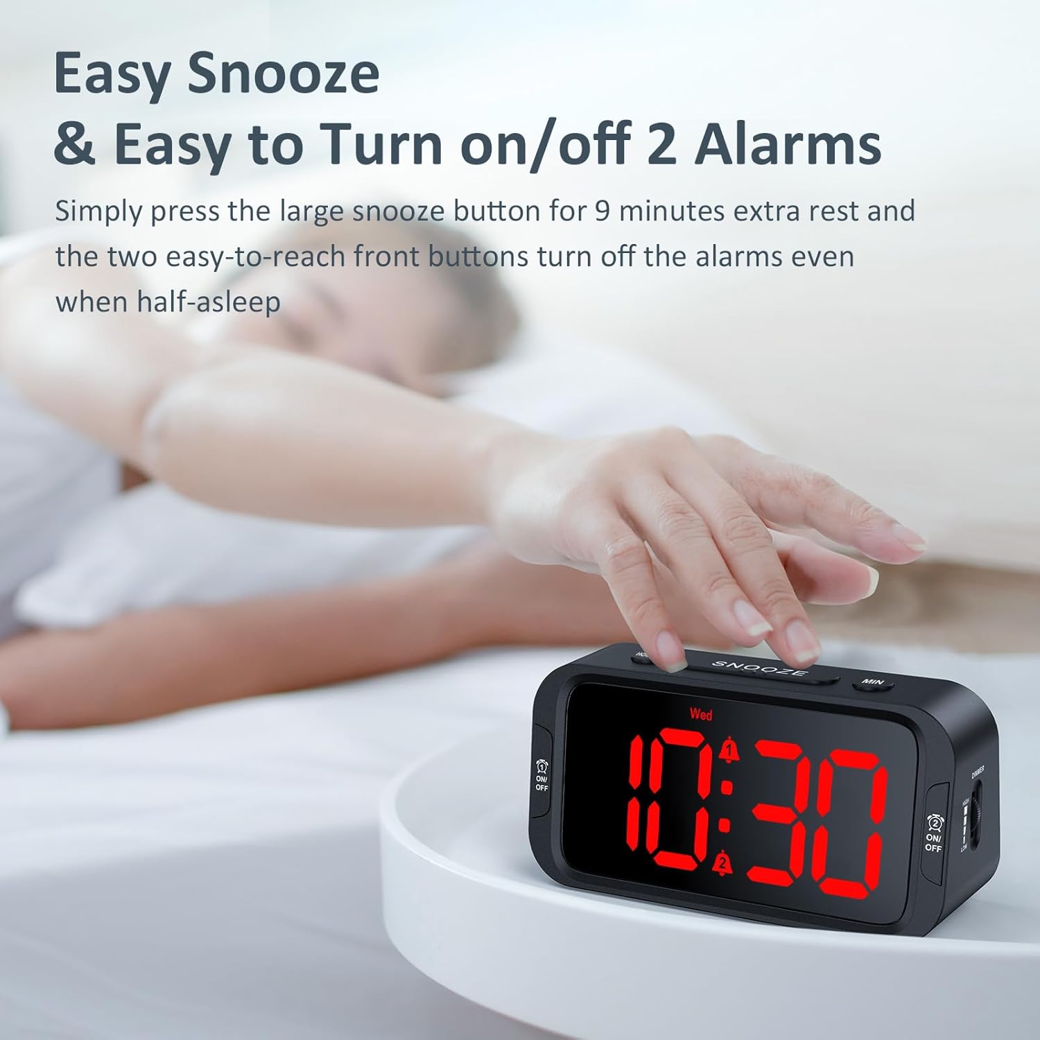 A hand pressing the large SNOOZE button on top of the alarm clock.