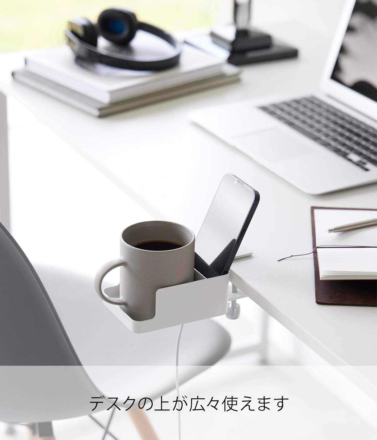 A smartphone being charged while resting in the holder, with the charging cable passing through the bottom cutout.