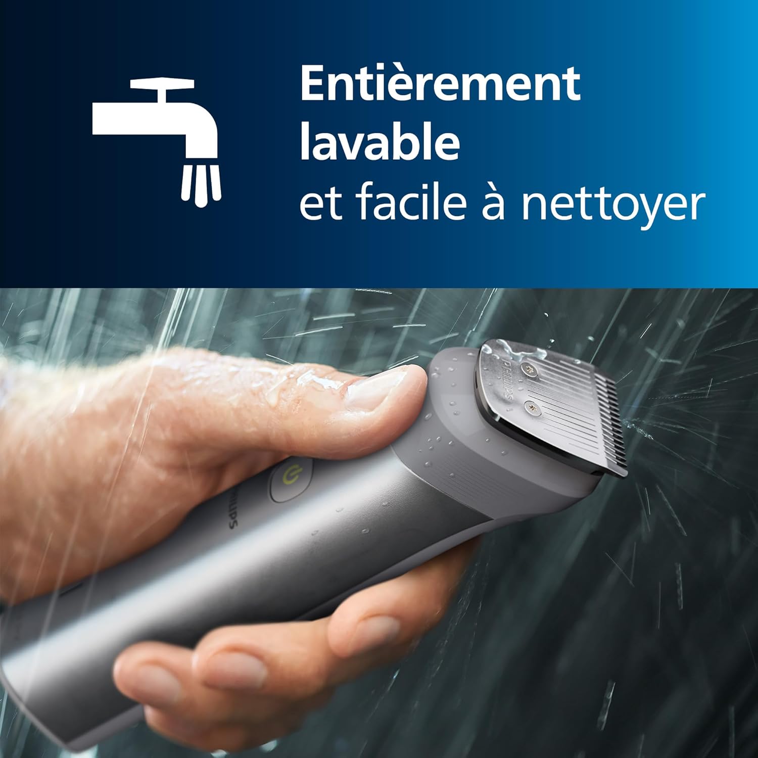 Hand holding the Philips Multigroom trimmer under running water, demonstrating its washability.