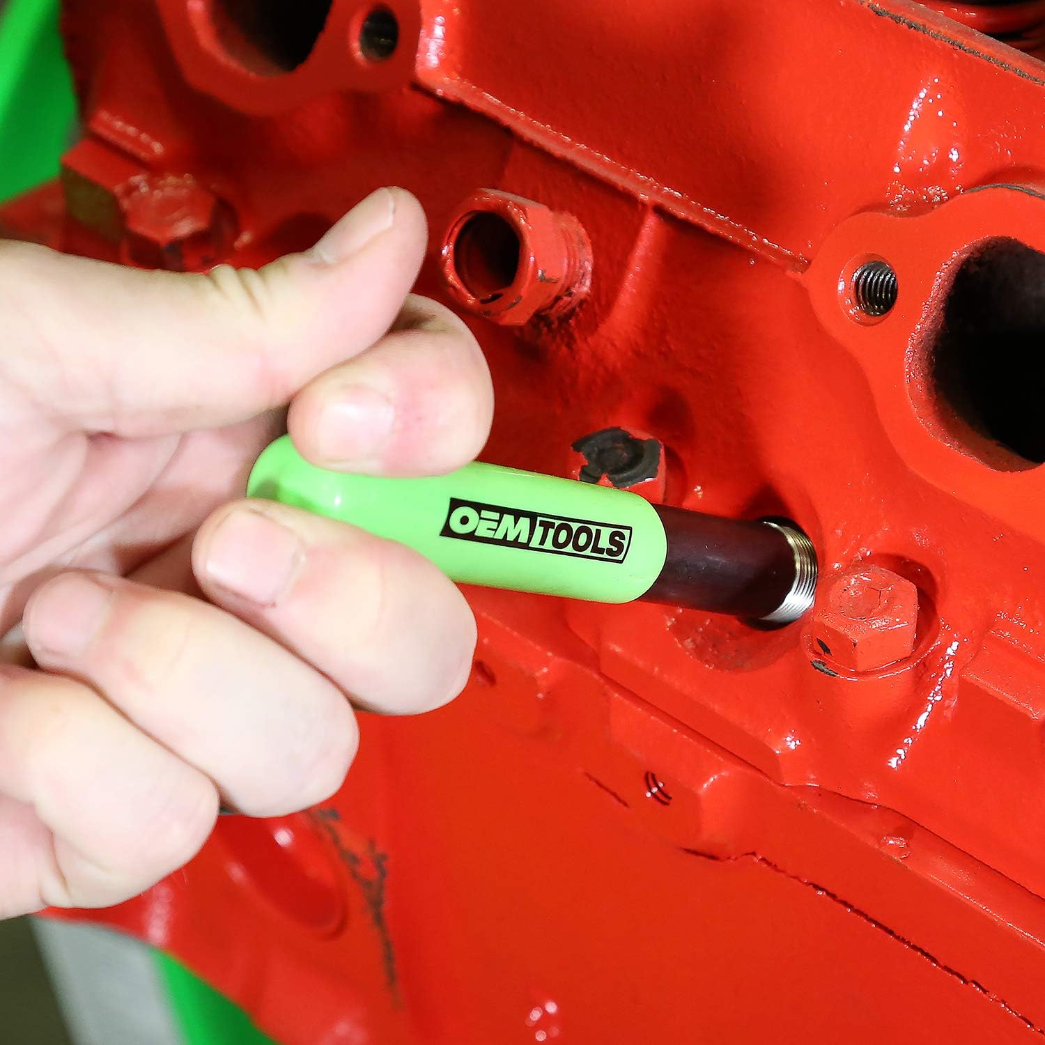Using the OEMTOOLS installation tool to insert a thread repair coil into an engine block.