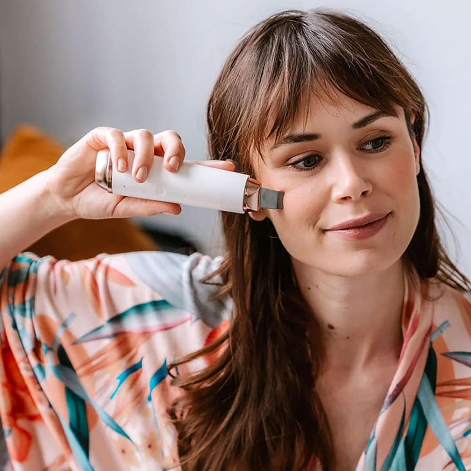 Woman using the Beautifly B-Plasma PRO device for cavitation peeling on her cheek