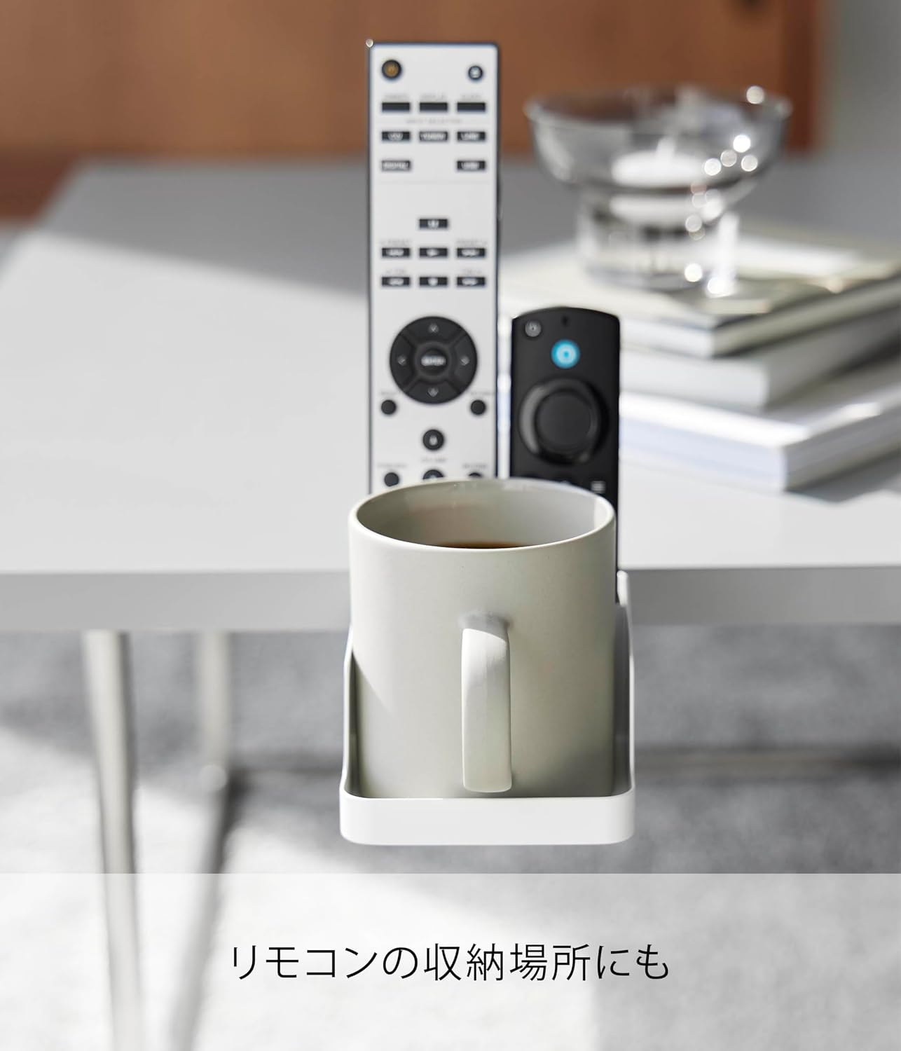 The holder being used to store a remote control, demonstrating its versatility beyond just smartphones and cups.