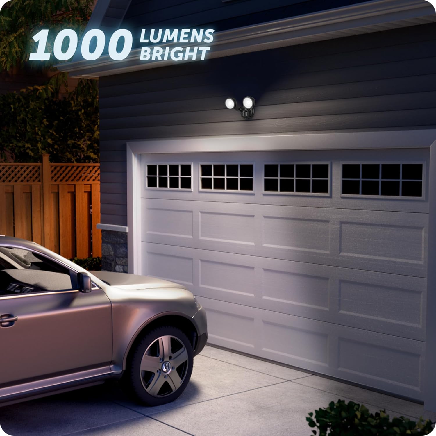 The flood light illuminating a garage and driveway at night, demonstrating its 1000 lumen brightness.