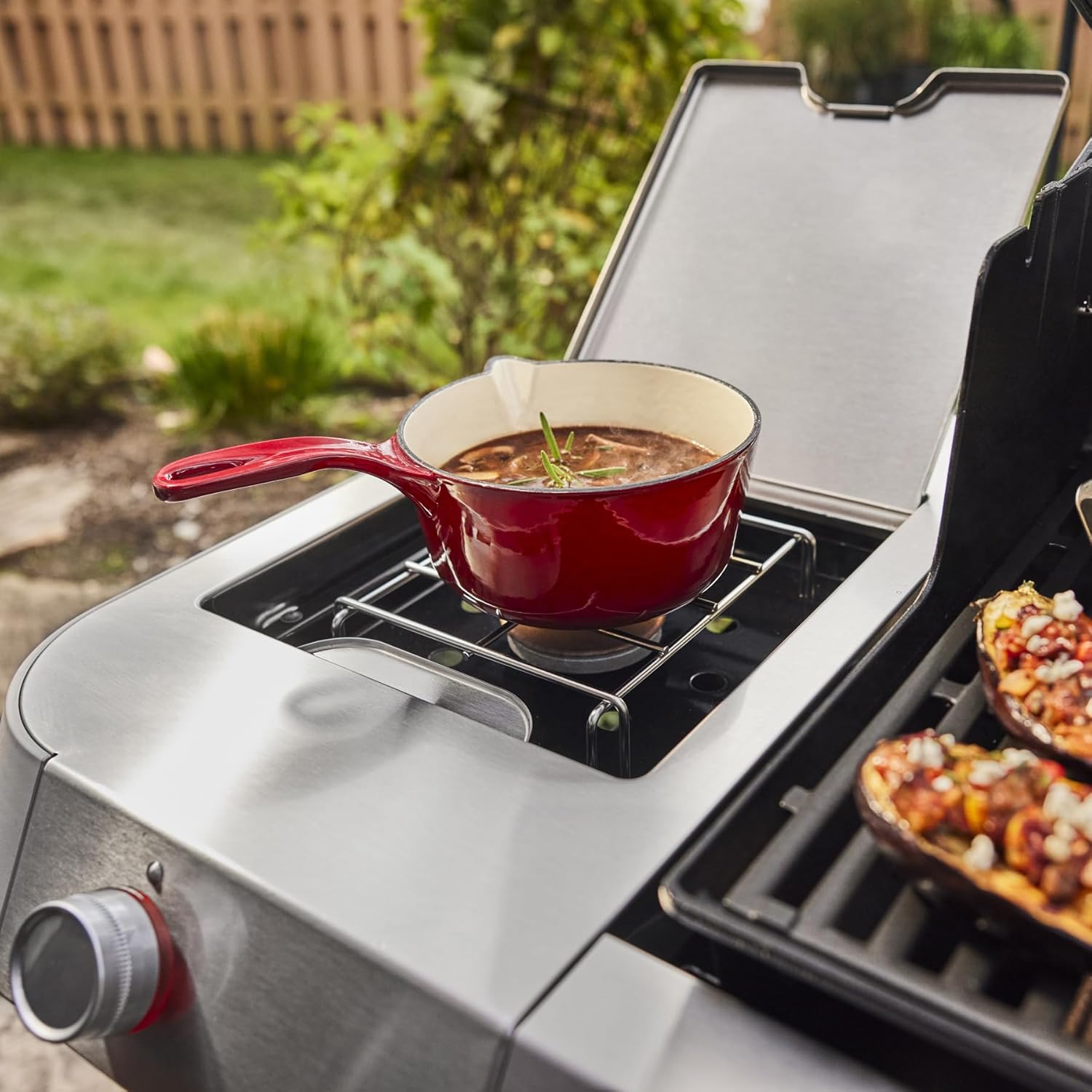 Side burner of the Weber Genesis E-335 grill in use with a pot.